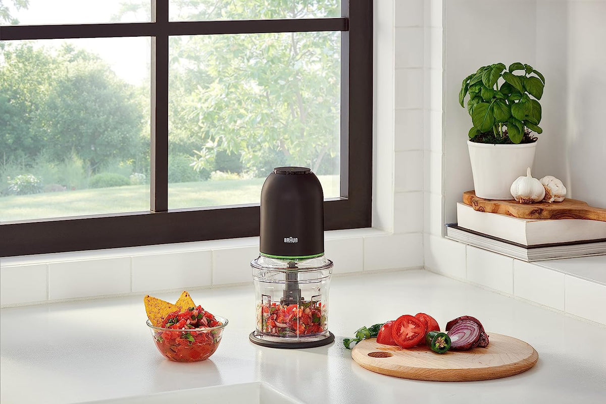 Black mini food chopper on kitchen counter with clear jar and black lid