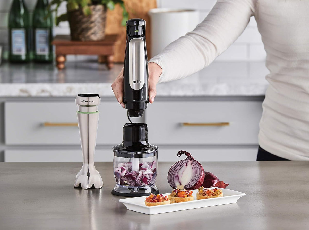 Braun stainless steel hand blender with whisk and measuring cup during use