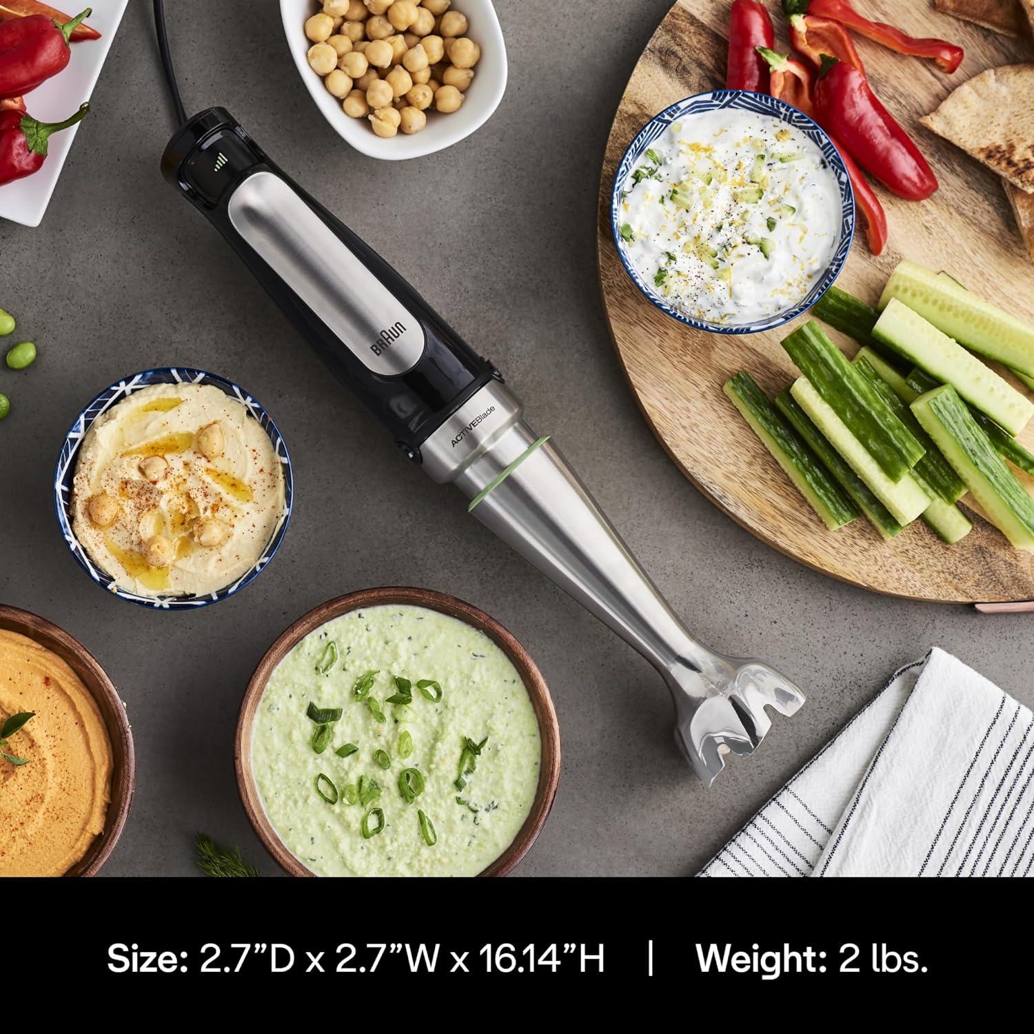 Braun hand blender with blending wand and attachments near bowls of blended food.