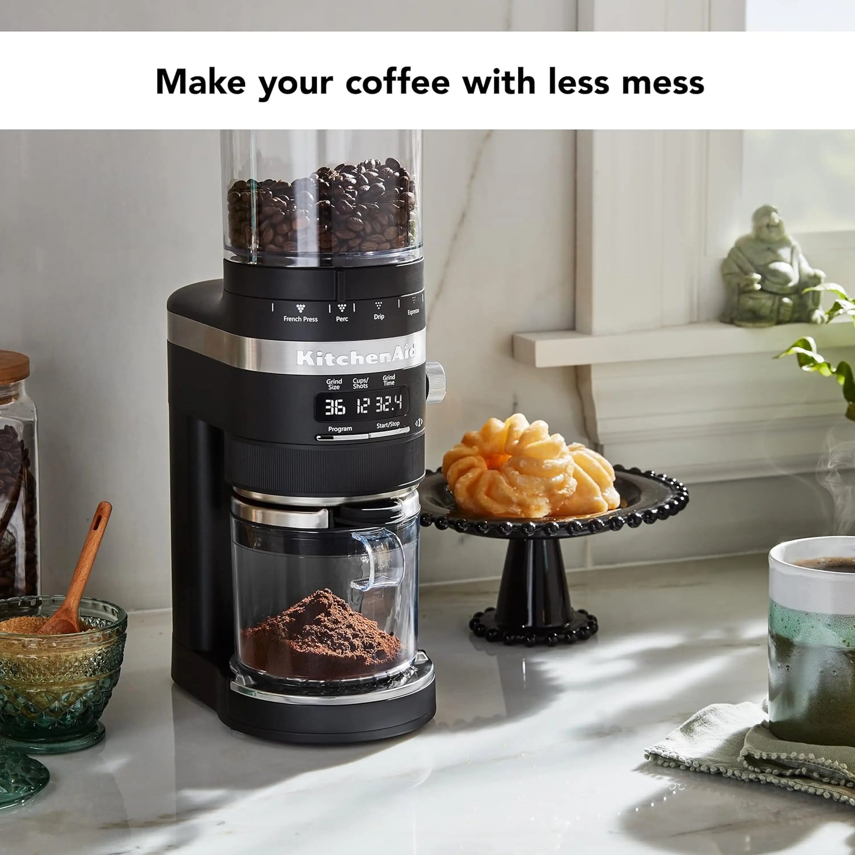 Black matte burr coffee grinder on countertop with clear grounds drawer and hopper