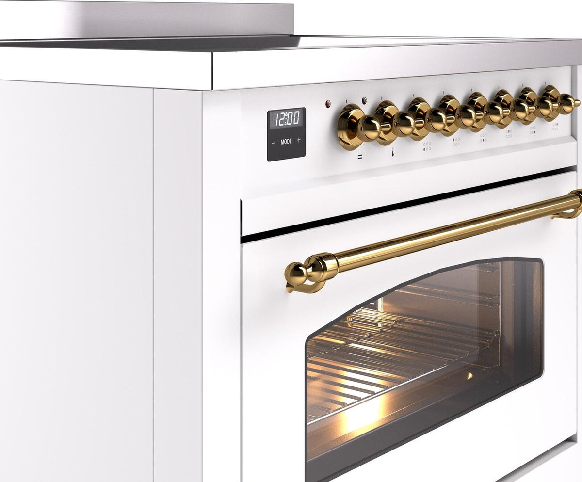 White induction range control panel with brass knobs and long brass oven handle