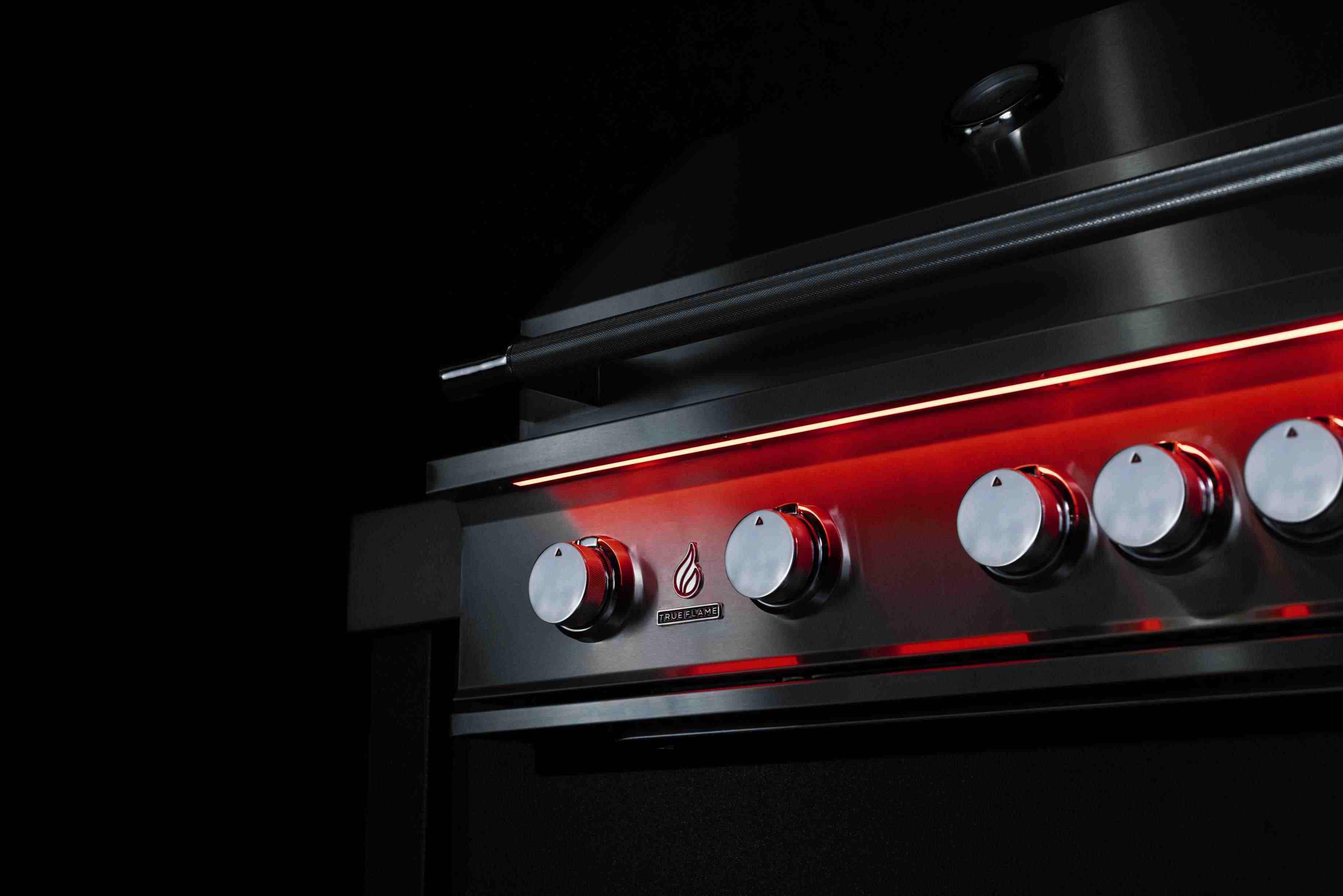 Stainless built-in propane grill control knobs with glowing red indicator