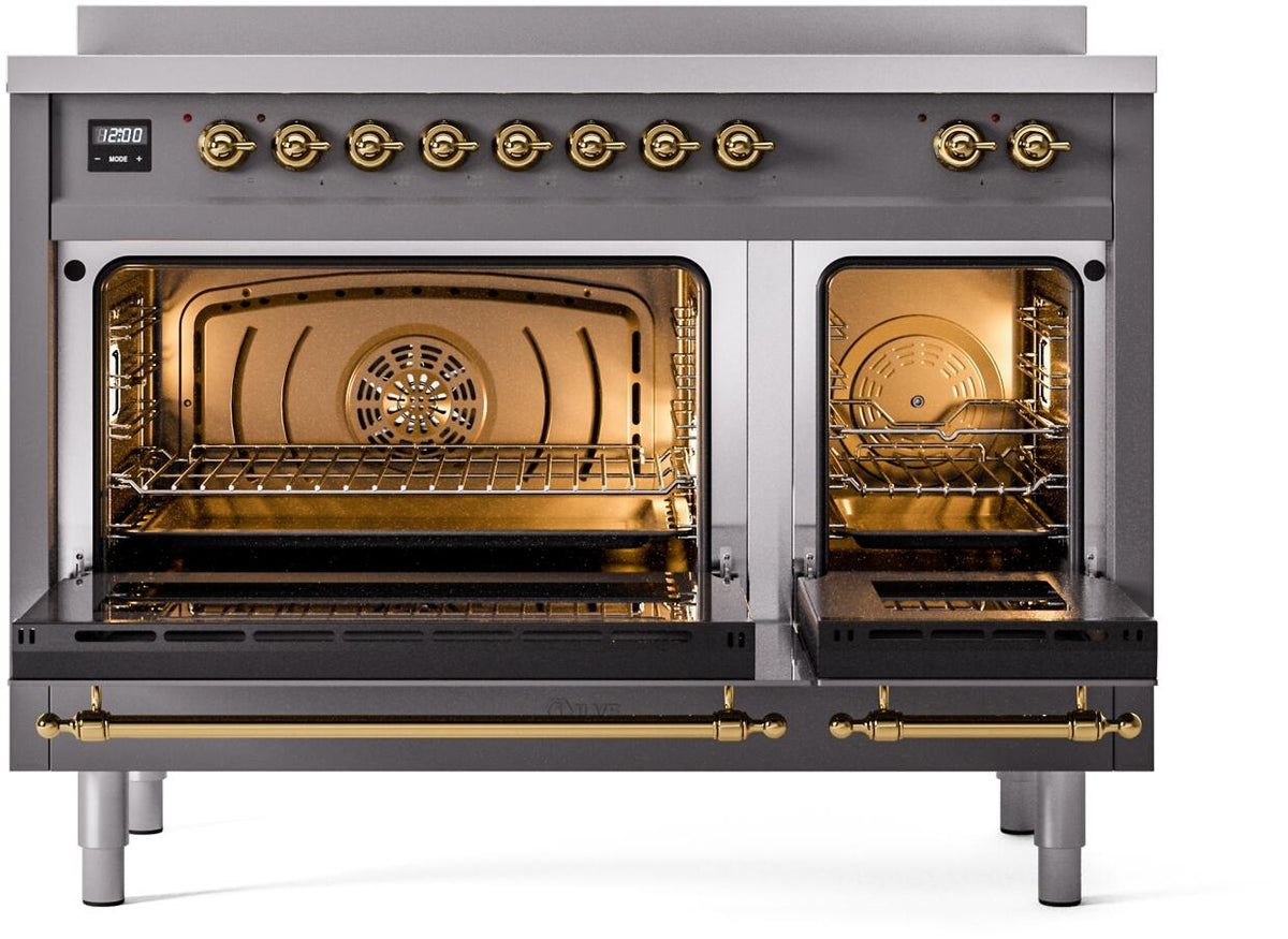 Matte graphite double-oven door open, showing racks and warm interior lighting with brass accents.