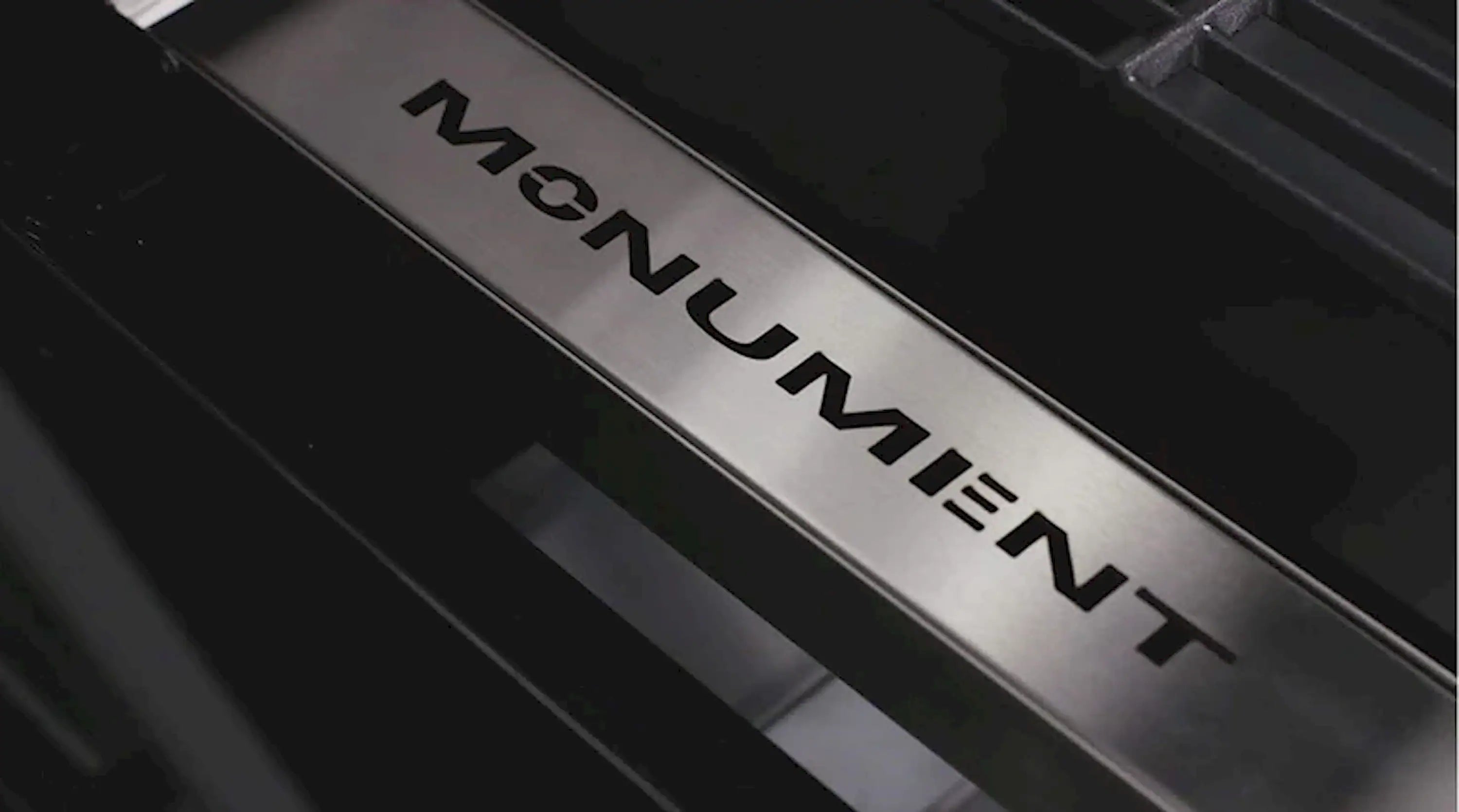 Close-up of Monument smoker box front panel with “MONUMENT” logo