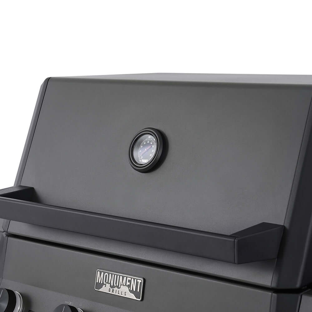 Black grill lid with round thermometer and Monument branding on front