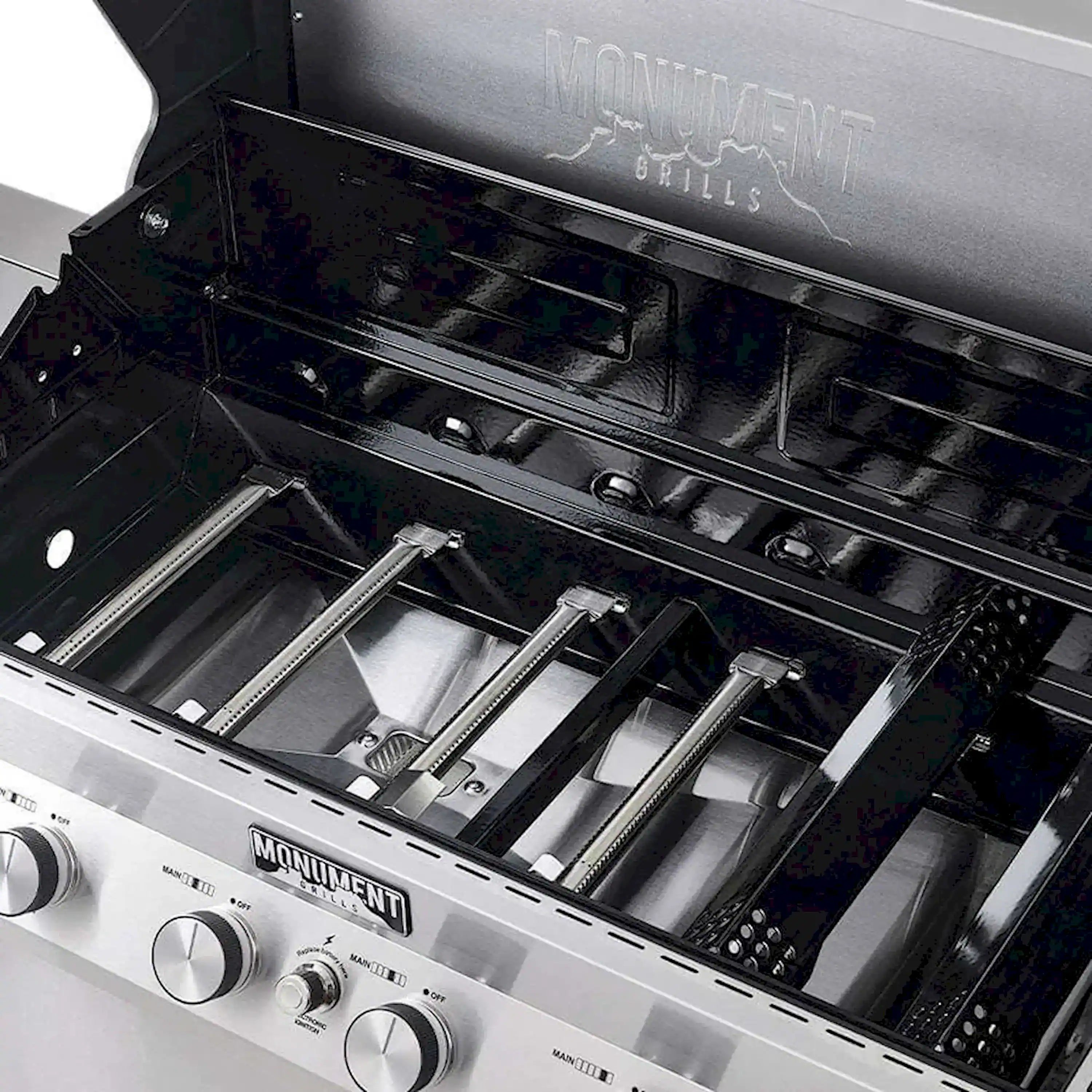 Open gas grill hood with burner tubes and stainless grates visible