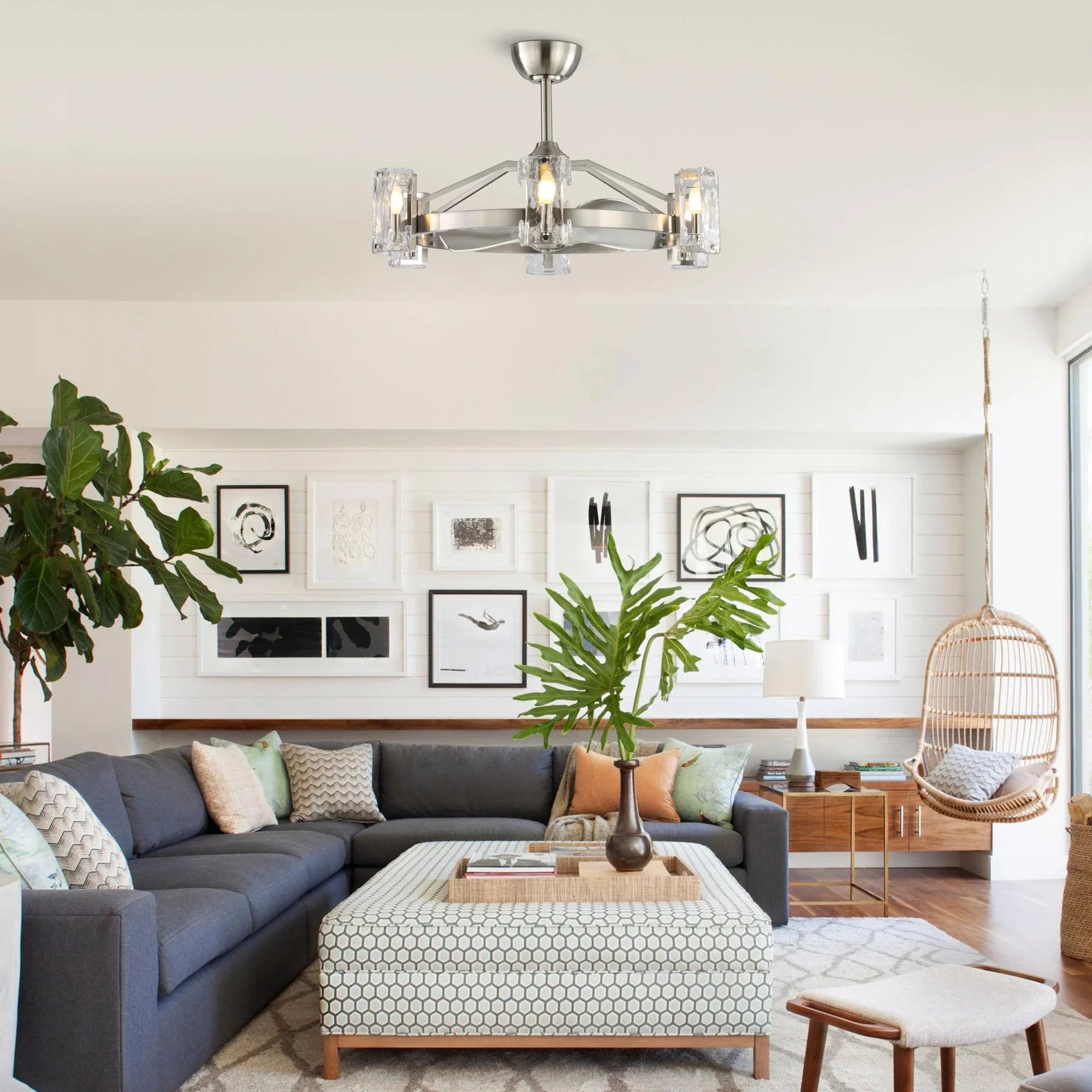 Brushed nickel ceiling fan with clear glass light shades installed above a modern living room