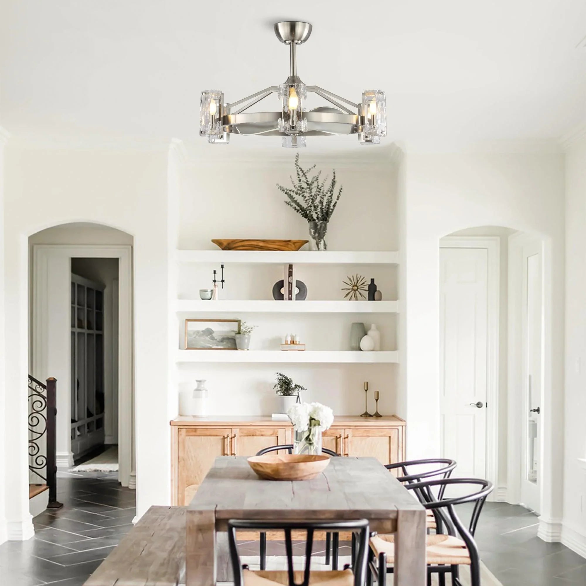 Brushed nickel ceiling fan with clear glass light shades mounted in a living room ceiling