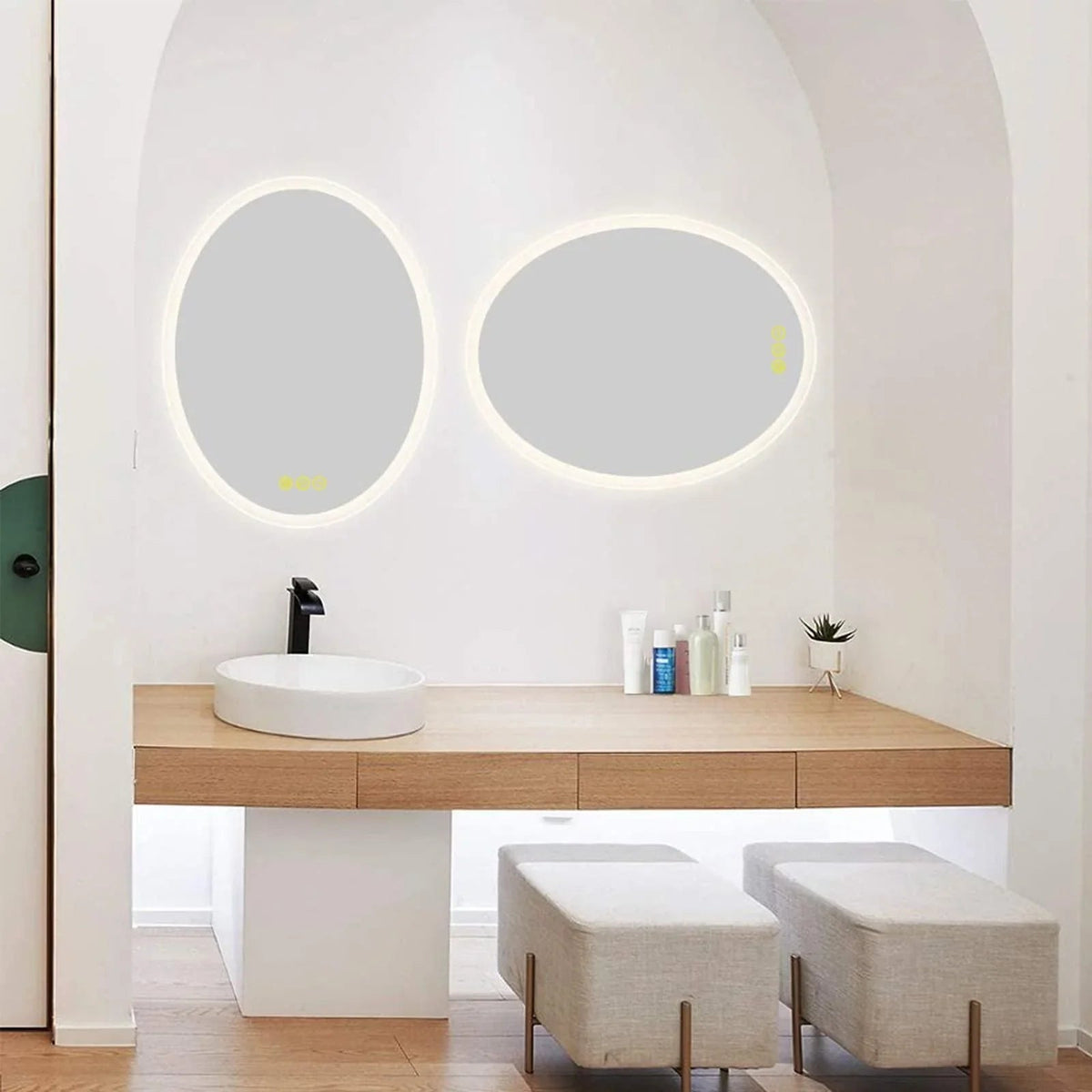 Set of two wall-mounted oval LED mirrors with glowing light rings above vanity
