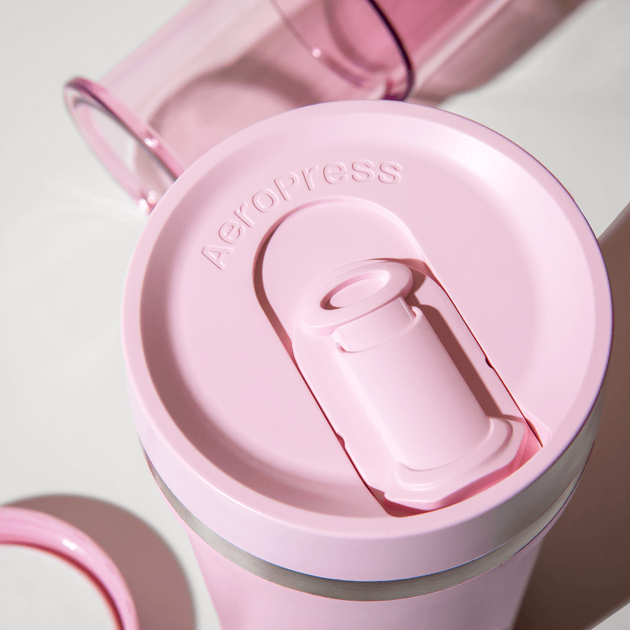 Pink AeroPress lid and press button on insulated travel tumbler