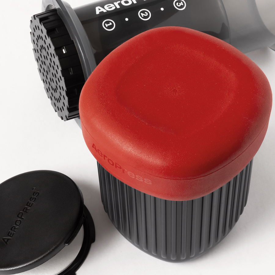 AeroPress travel mug with red silicone lid removed, showing filter basket