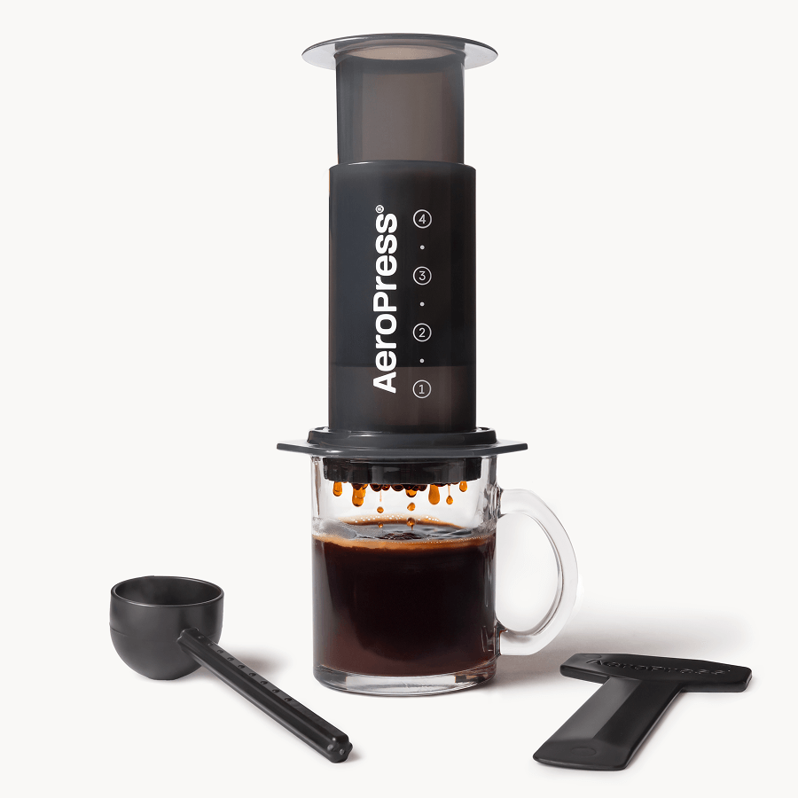 Black AeroPress coffee maker with plunger, filter cap, and numbered settings