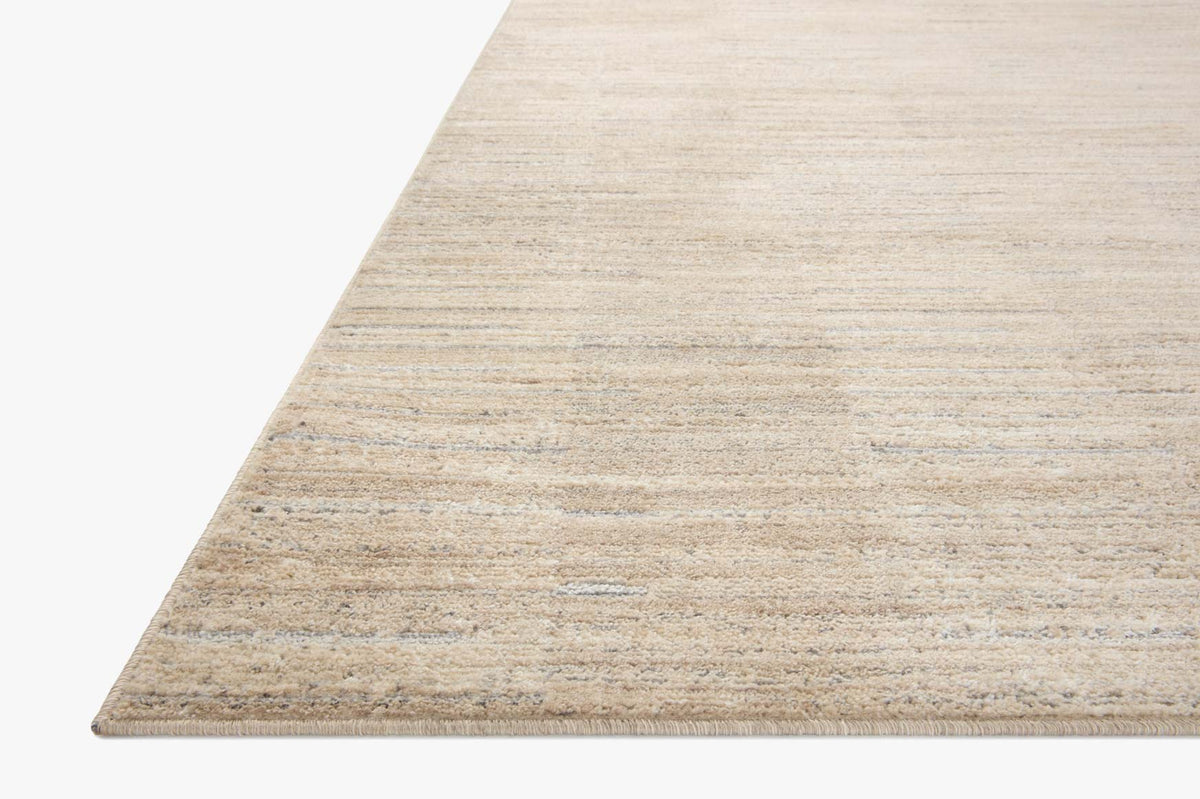 Natural and pebble area rug corner with ribbed linear pattern and textured surface