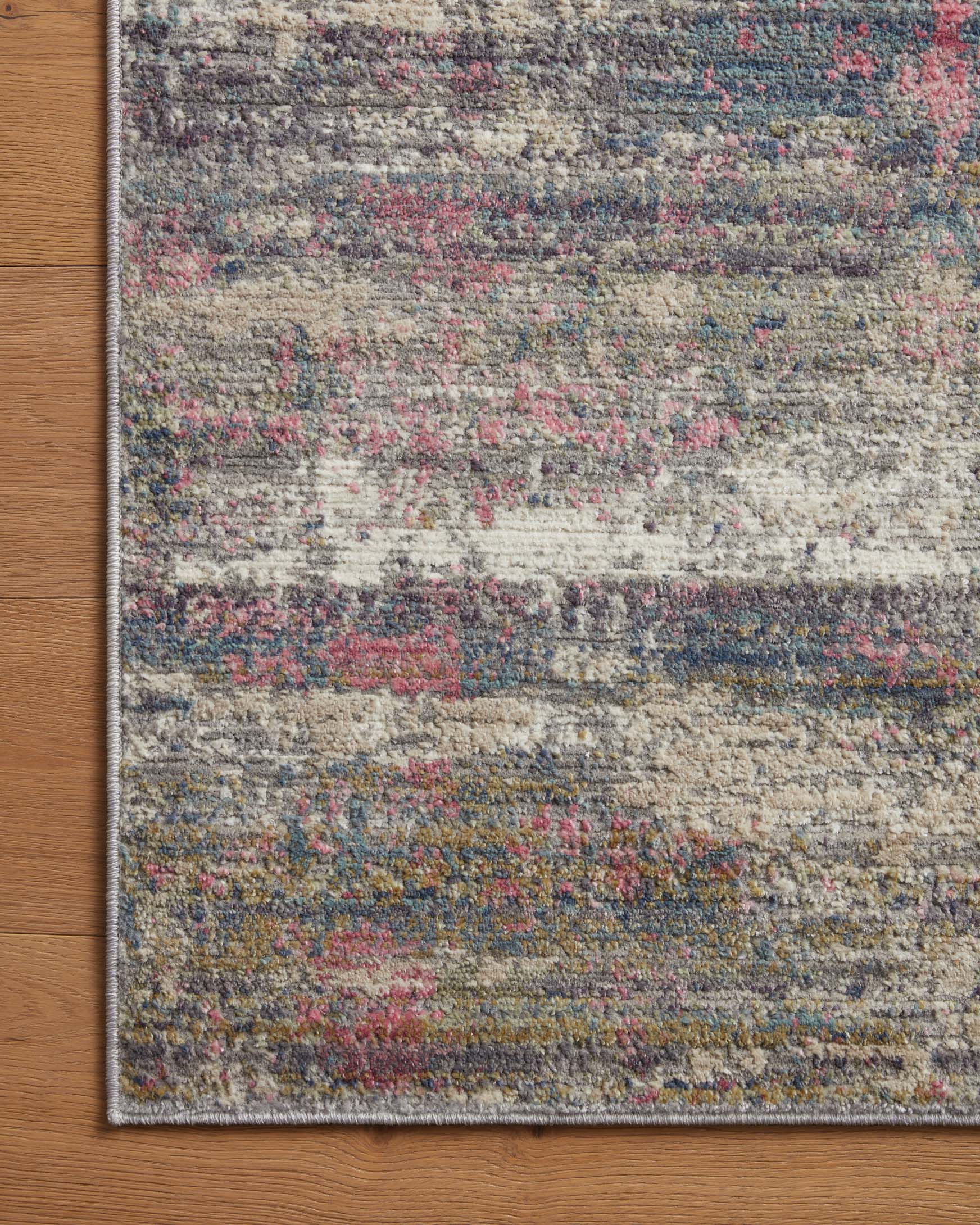 Flatwoven rug close-up, speckled abstract design in gray, blue, and berry tones