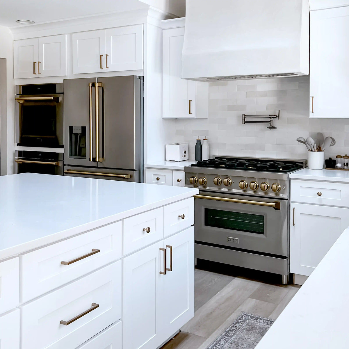 Stainless steel dual fuel range with bronze knobs and oven door, built-in layout
