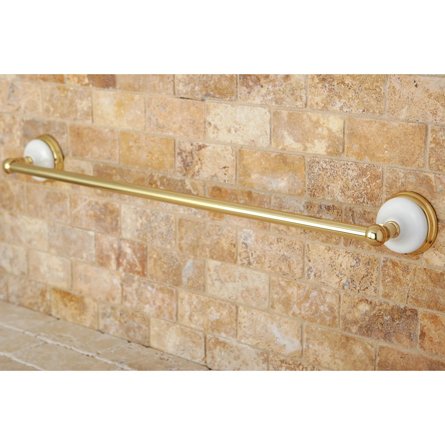 Polished brass single towel bar mounted with round end bases on brick wall