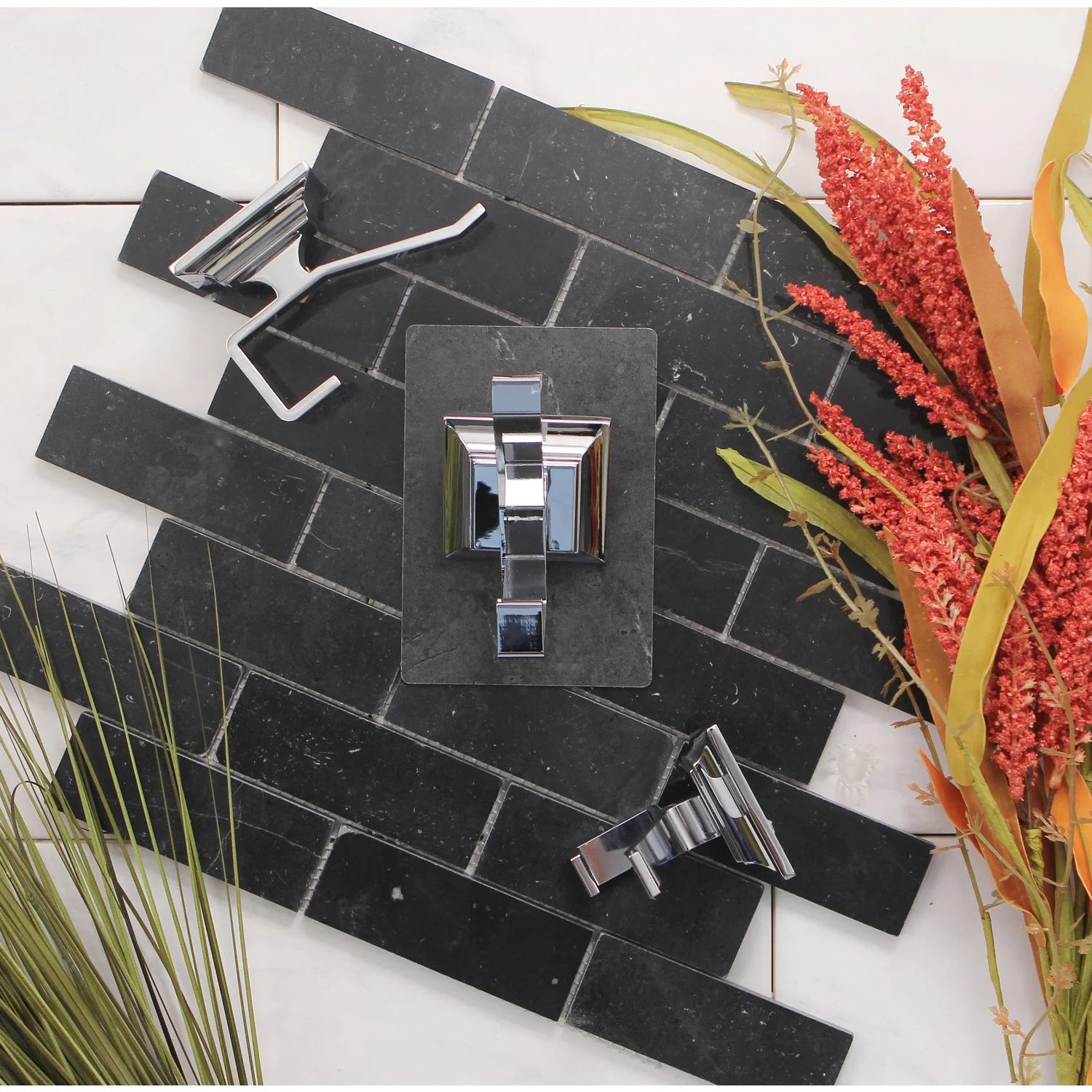 Polished chrome single towel/robe hook on dark tile wall