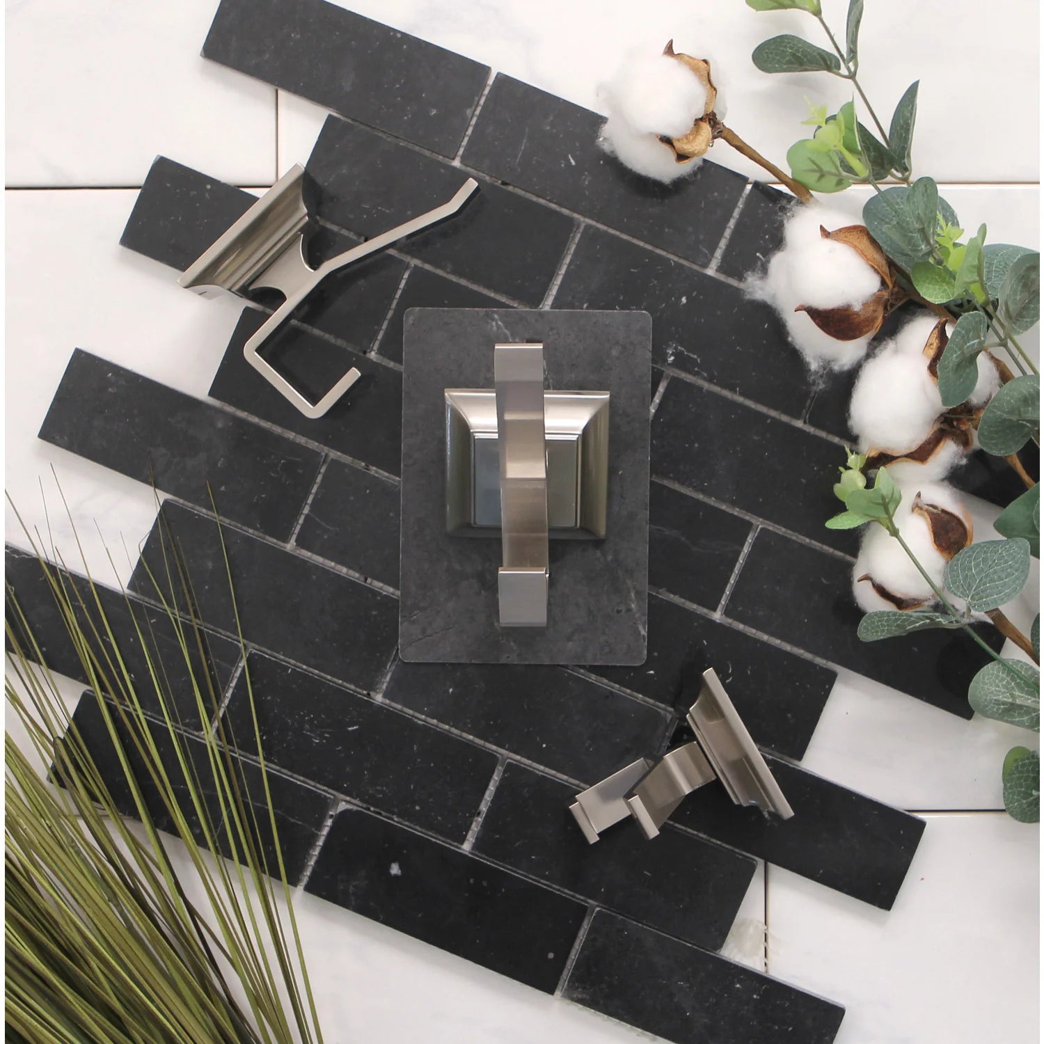 Brushed nickel robe hook mounted on dark tile with square backplate