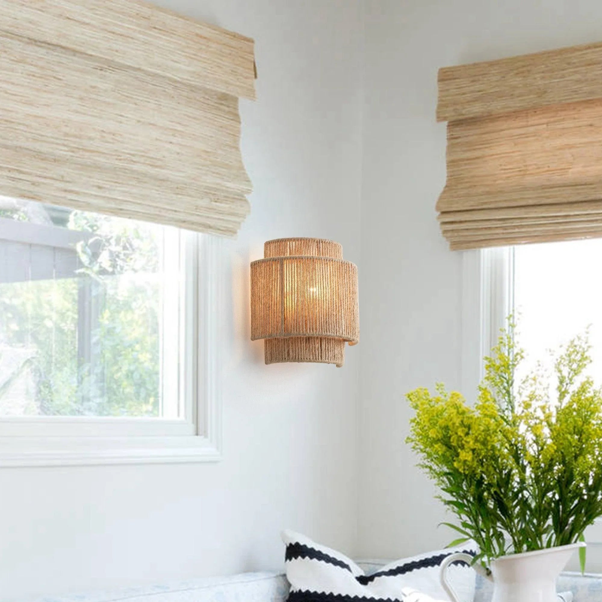 Brown rattan drum wall sconce with warm-glowing bulb
