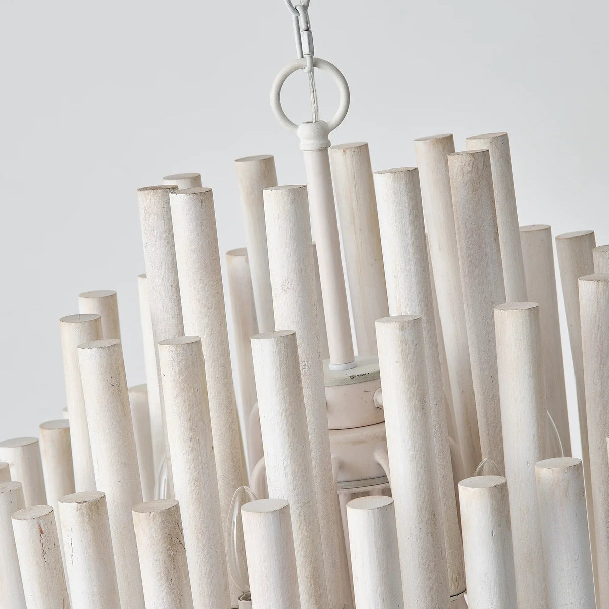 Close-up of white wooden cylinder shades on a chain for a 5-light chandelier