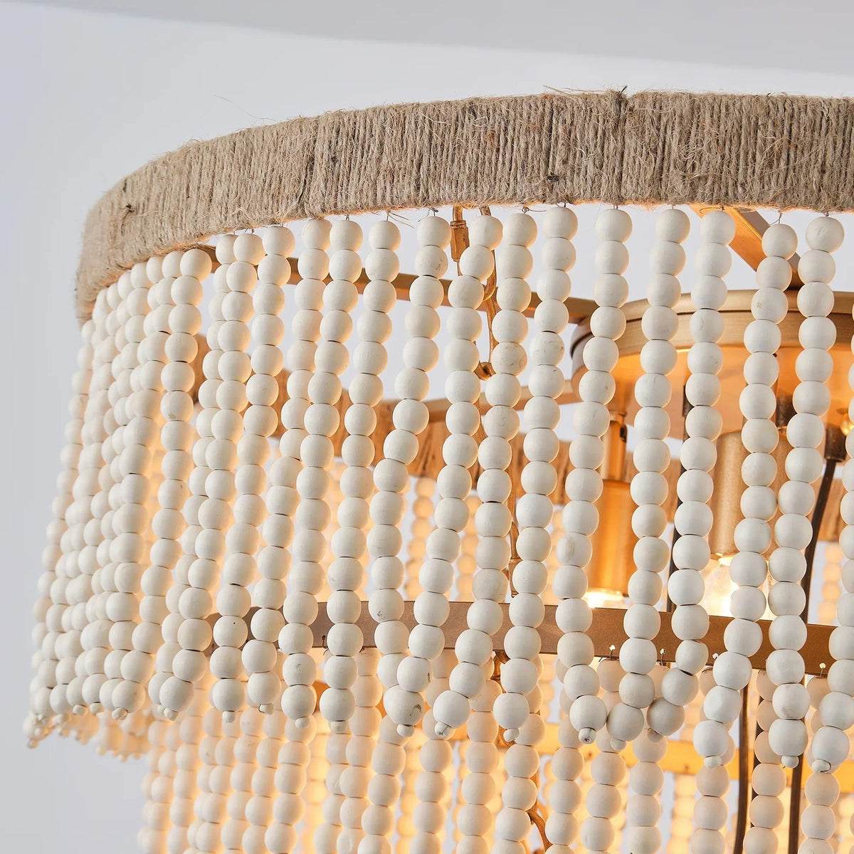 Close-up of golden beaded chandelier fringe strands over a hemp rope drum shade