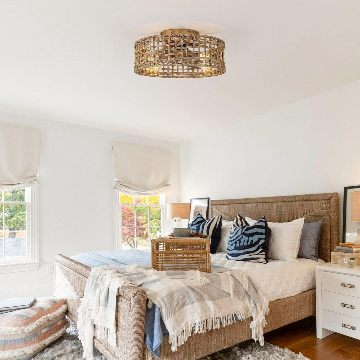 Golden rattan flush-mount ceiling fan with integrated light above a bed area.