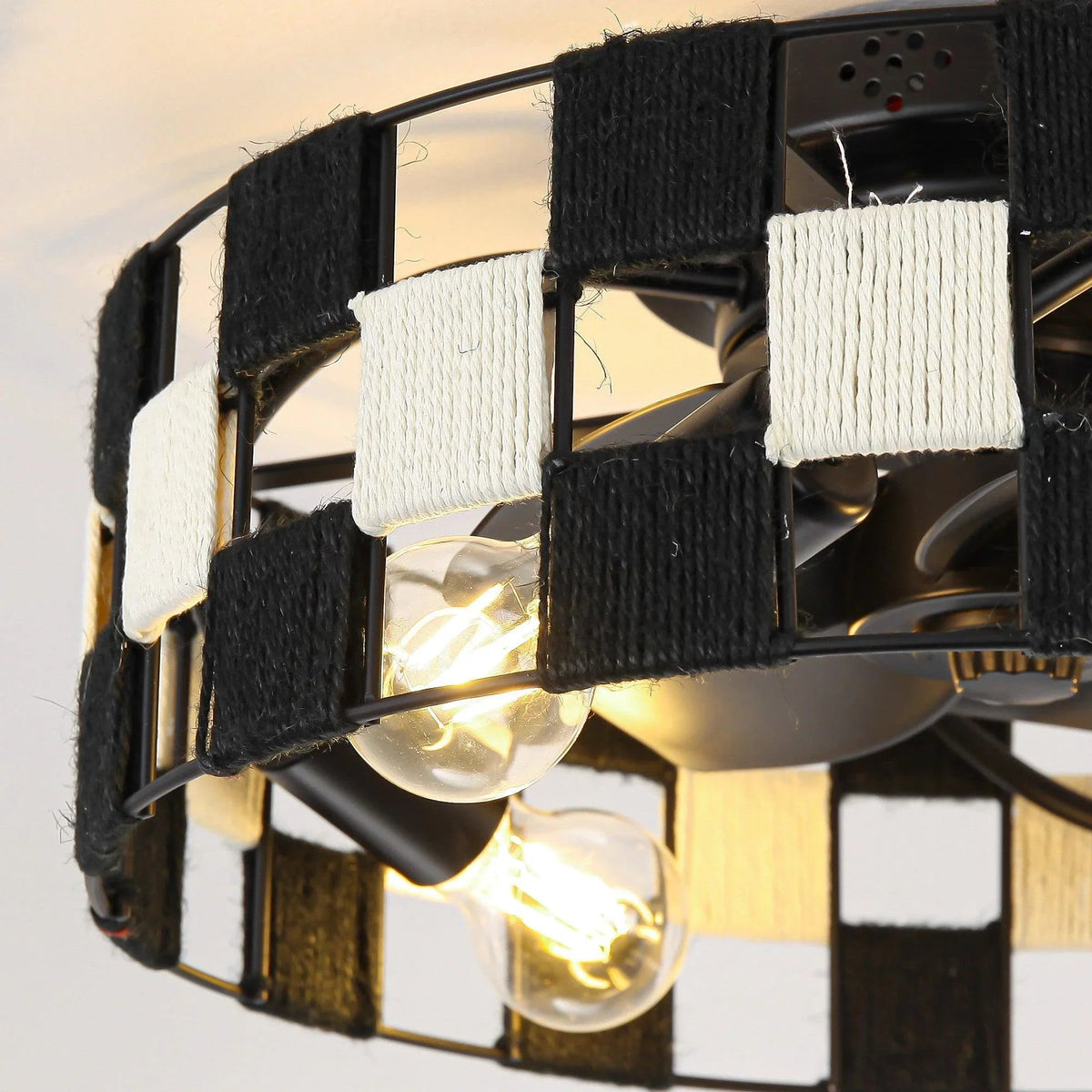 Close-up of black-and-white fabric cage around a ceiling fan light fixture