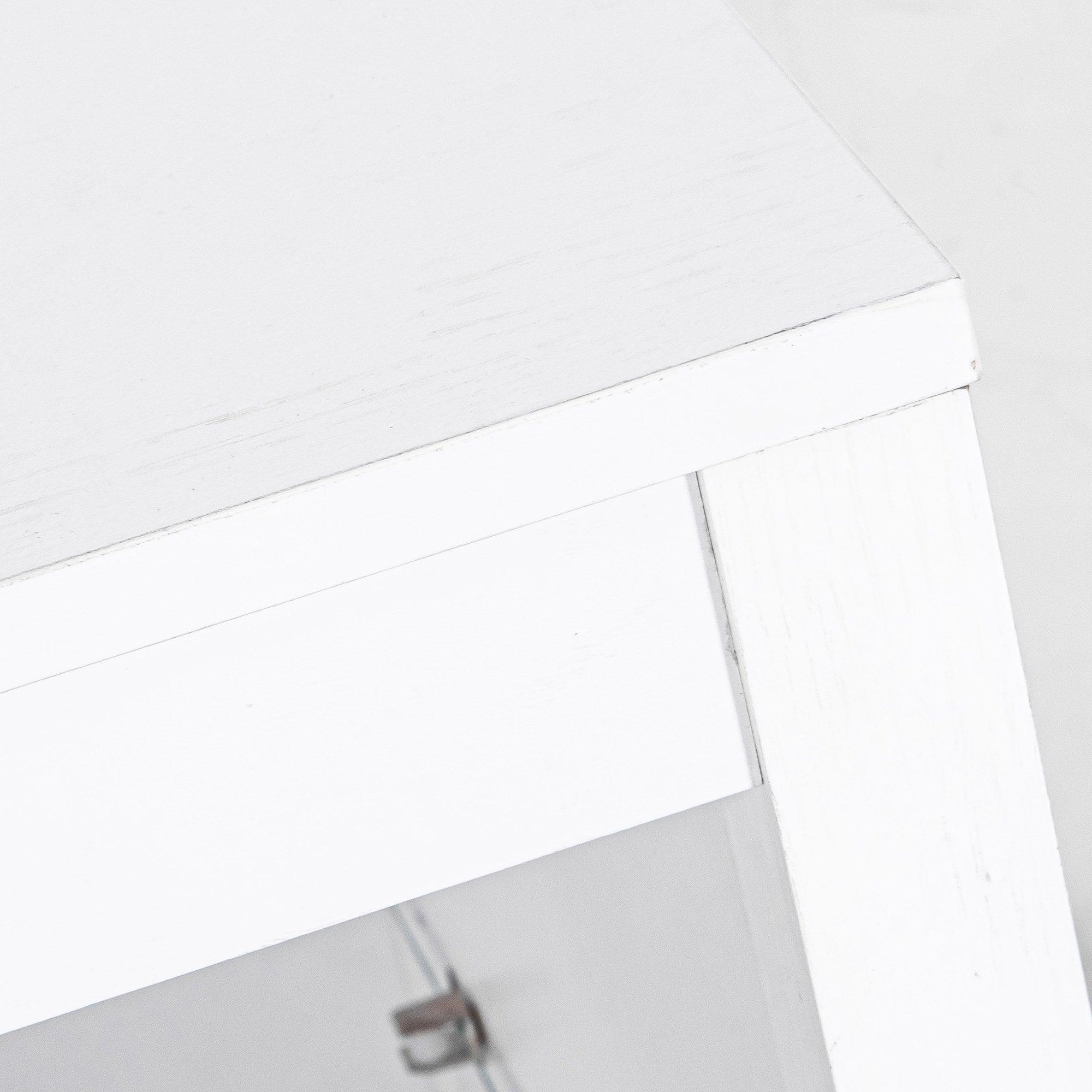 White modern TV stand corner with cabinet handle and glass shelf section