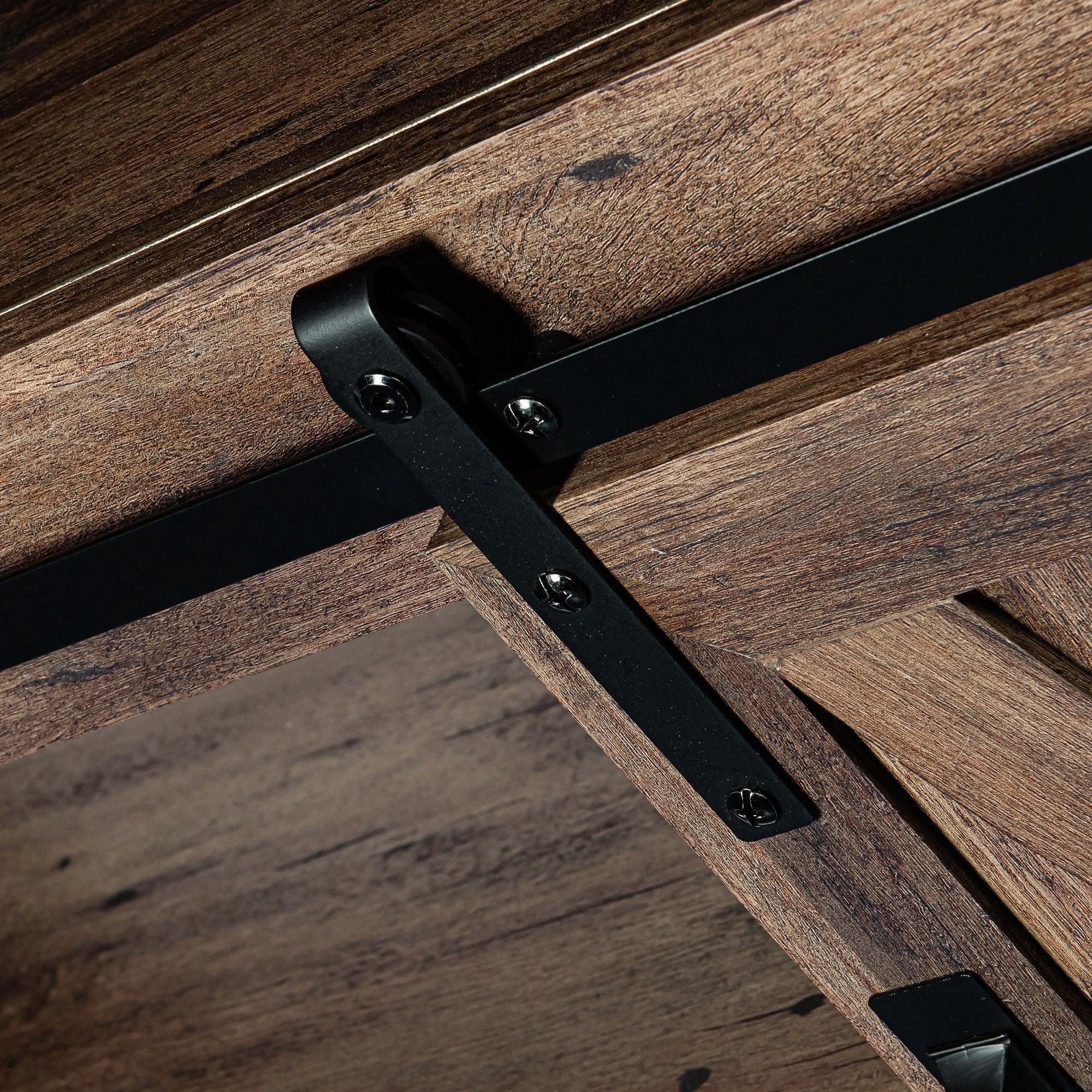 Barn door track and black metal latch on dark wood TV stand