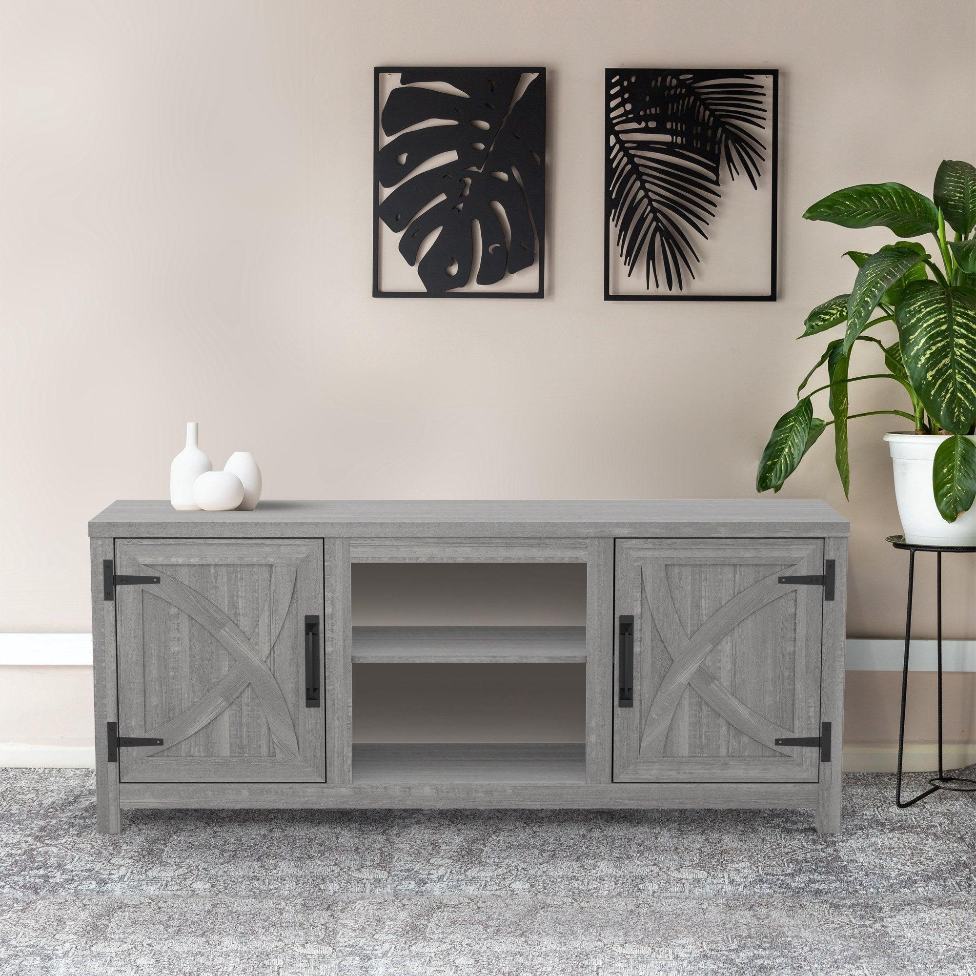 Grey farmhouse TV stand with two paneled doors, open center shelf, and black handles