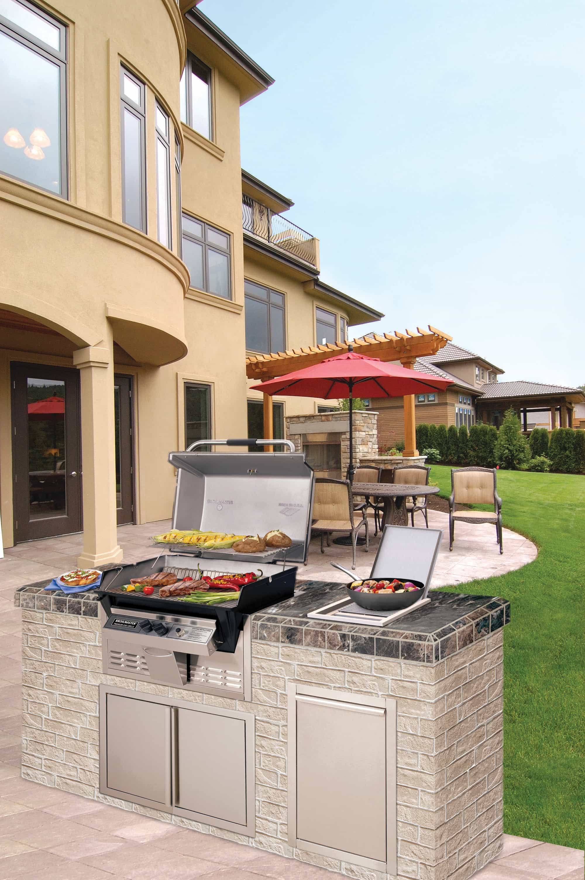 Outdoor gas grill with side burner on stone base, stainless hood and control panel