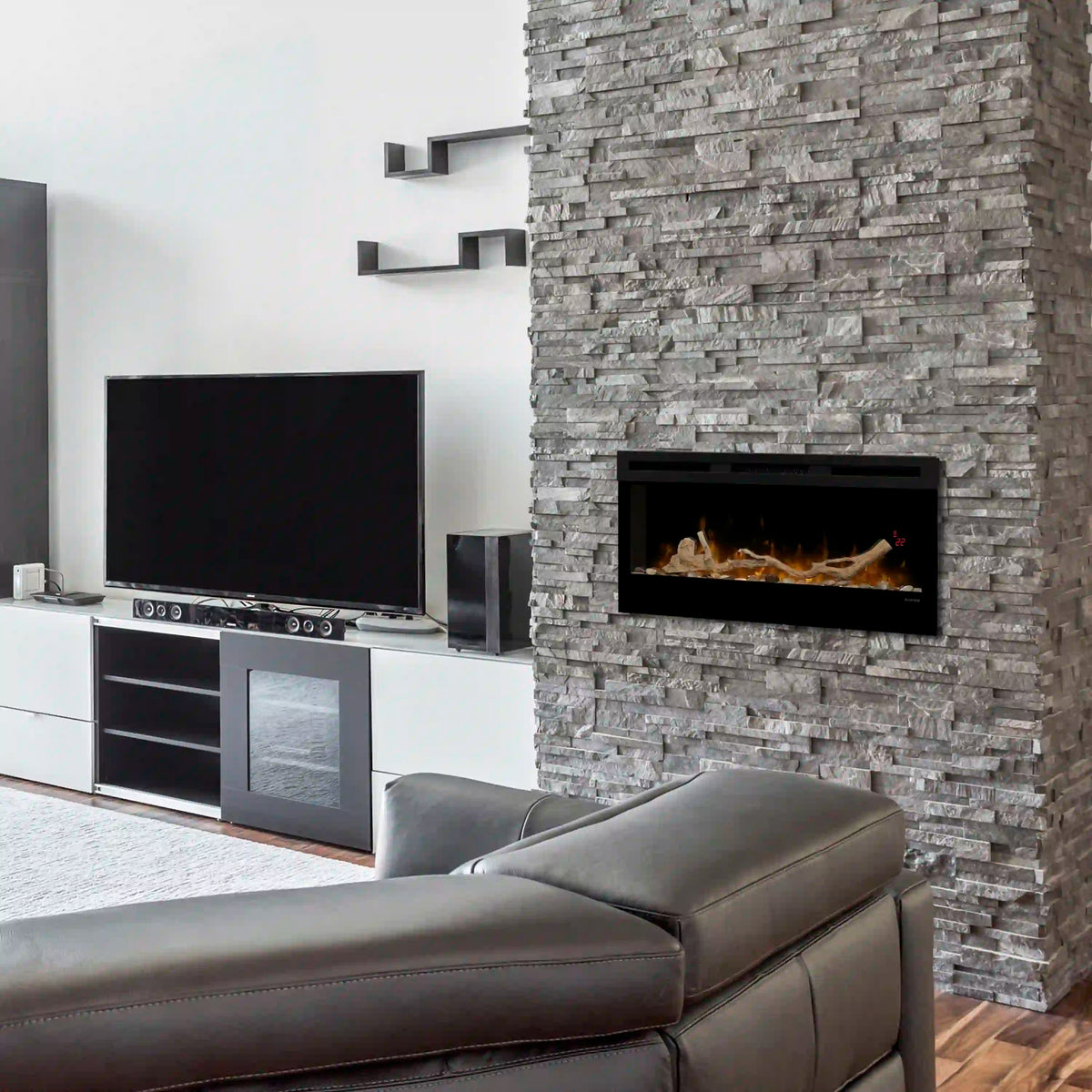 Linear fireplace insert with driftwood logs and river rock bed, flames visible