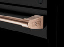 Rose-gold G&R engraved range handle on a black oven door.