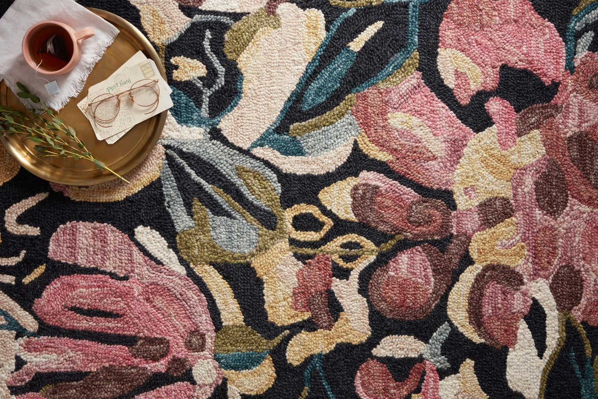 Close-up floral area rug pattern with black, berry, cream, teal woven texture