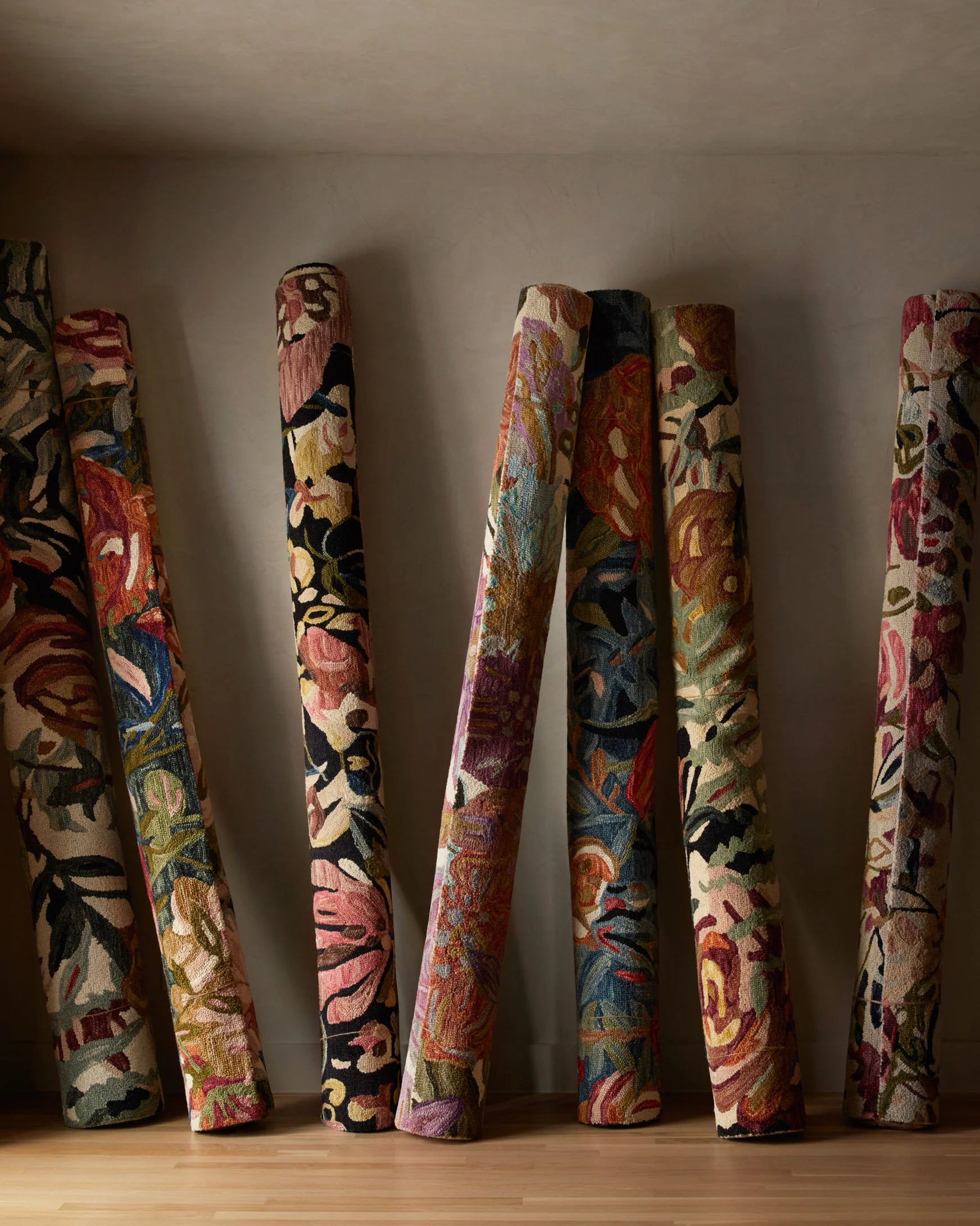 Floral accent rug rolls standing upright, ivory, raspberry, black multicolor design