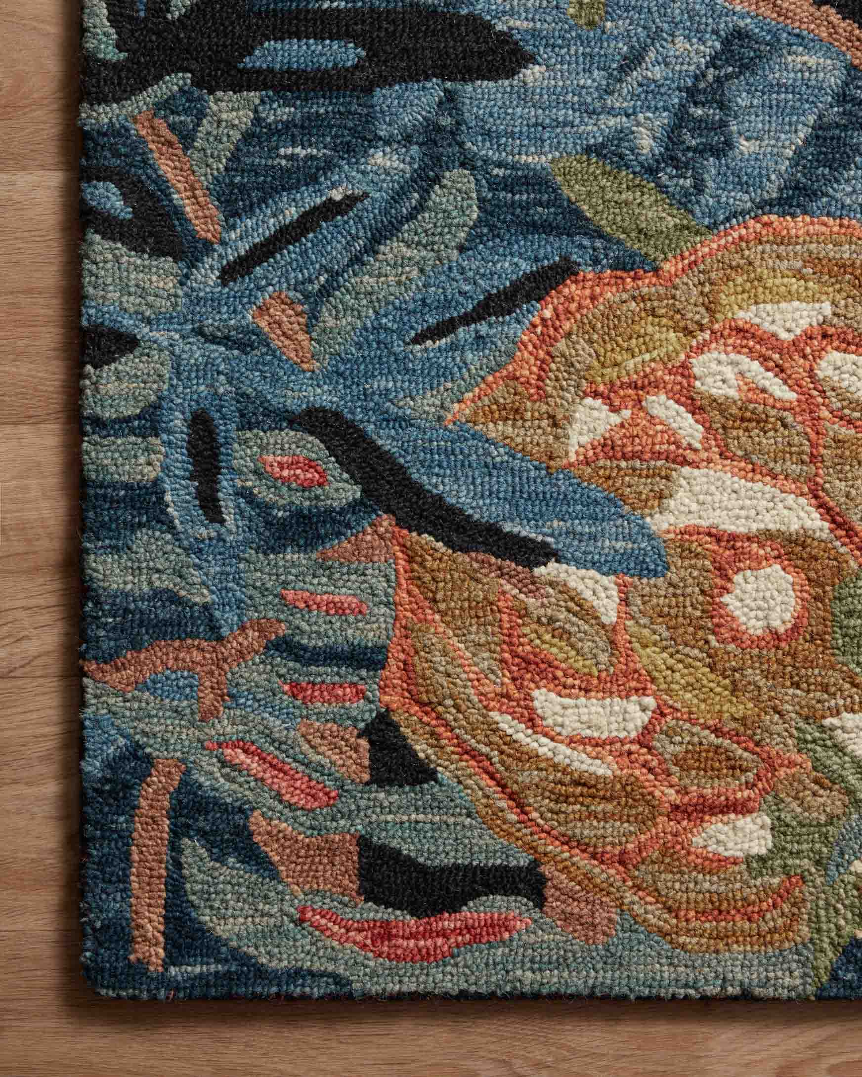 Loloi Belladonna area rug close-up, textured loop pile with blue, rust, and gold floral shapes