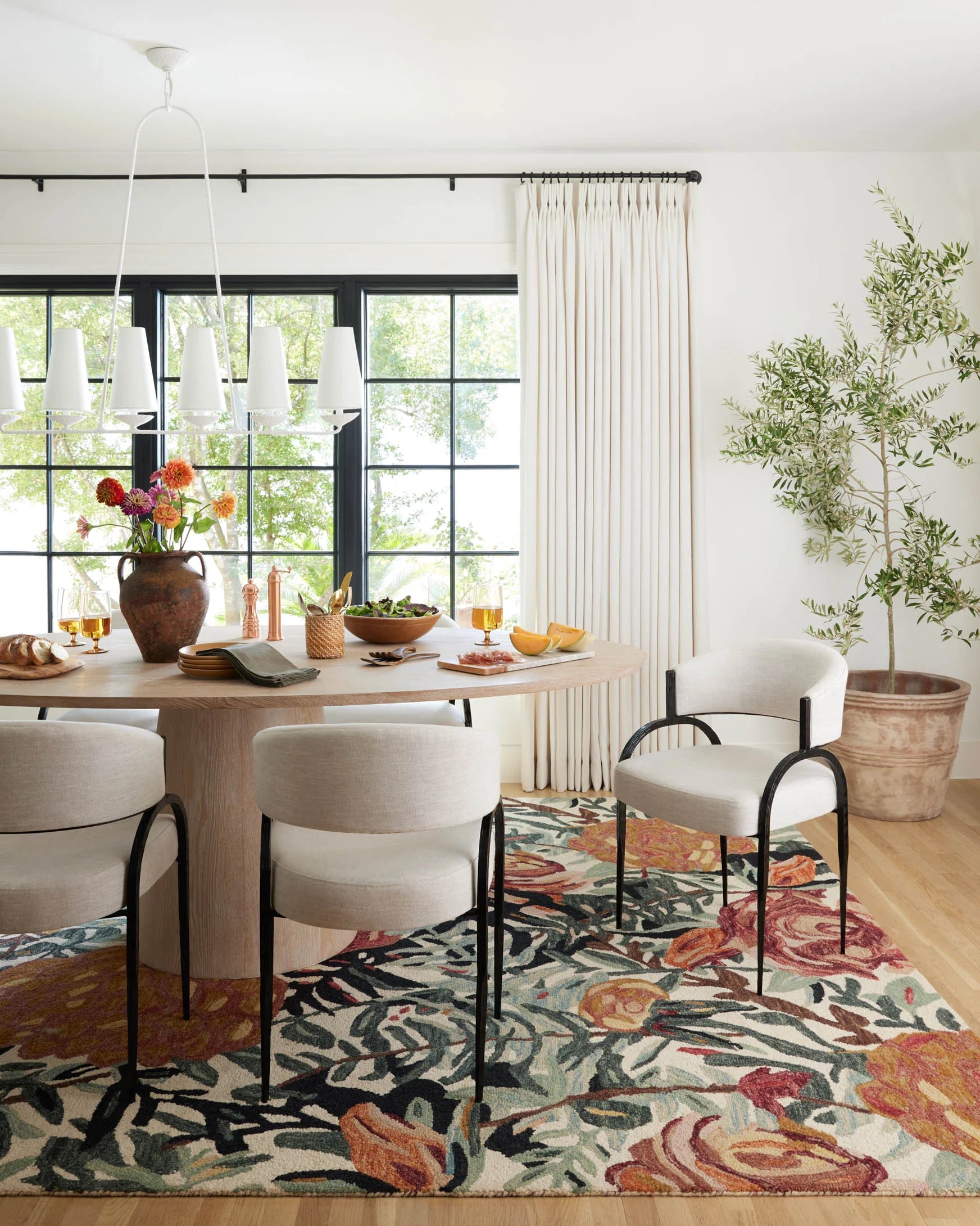Multicolor floral accent rug with dark outline, styled on the floor in a dining room
