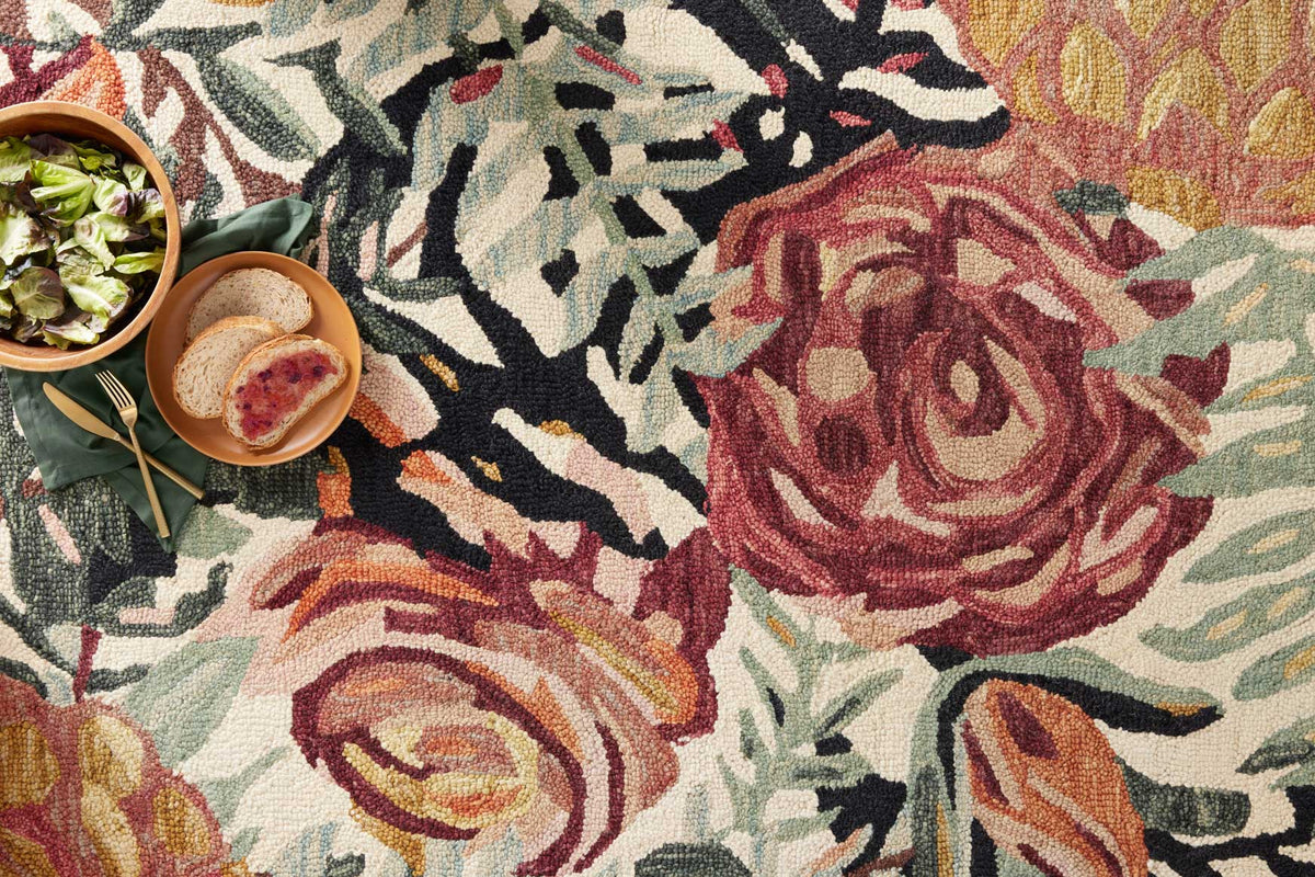 Close-up round rug weave with red and green floral pattern on an ivory background