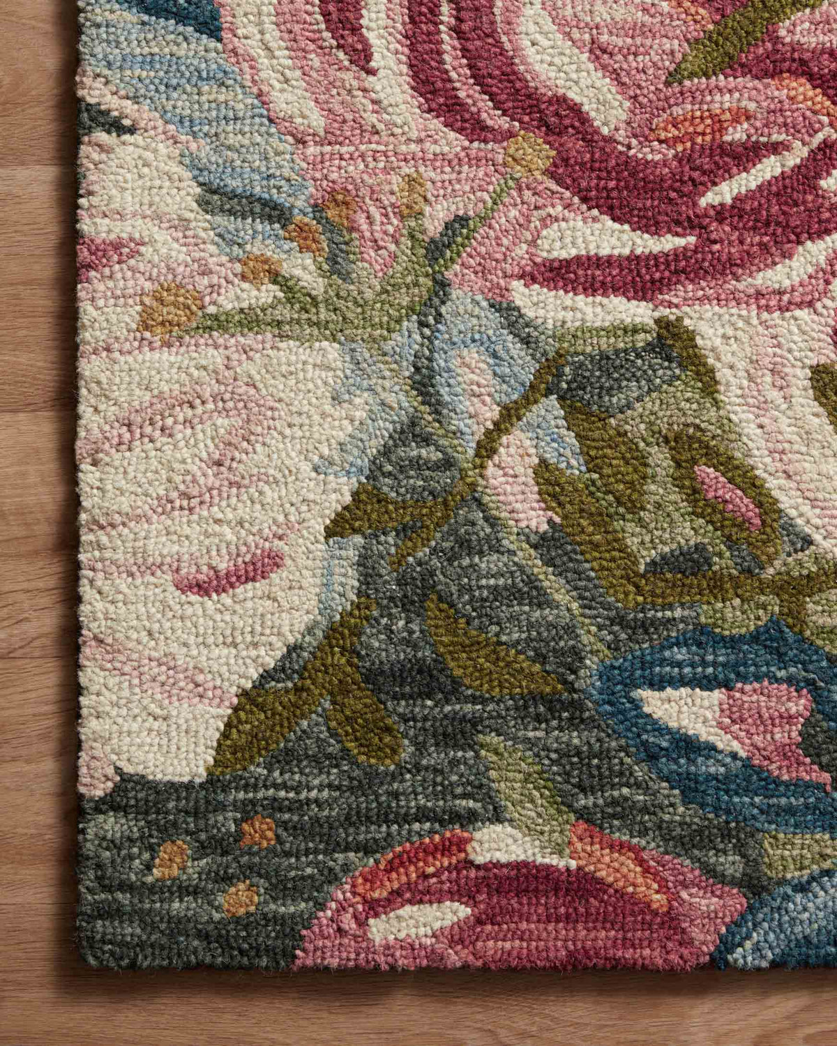 Floral area rug corner detail with textured pile and multicolor rose motifs