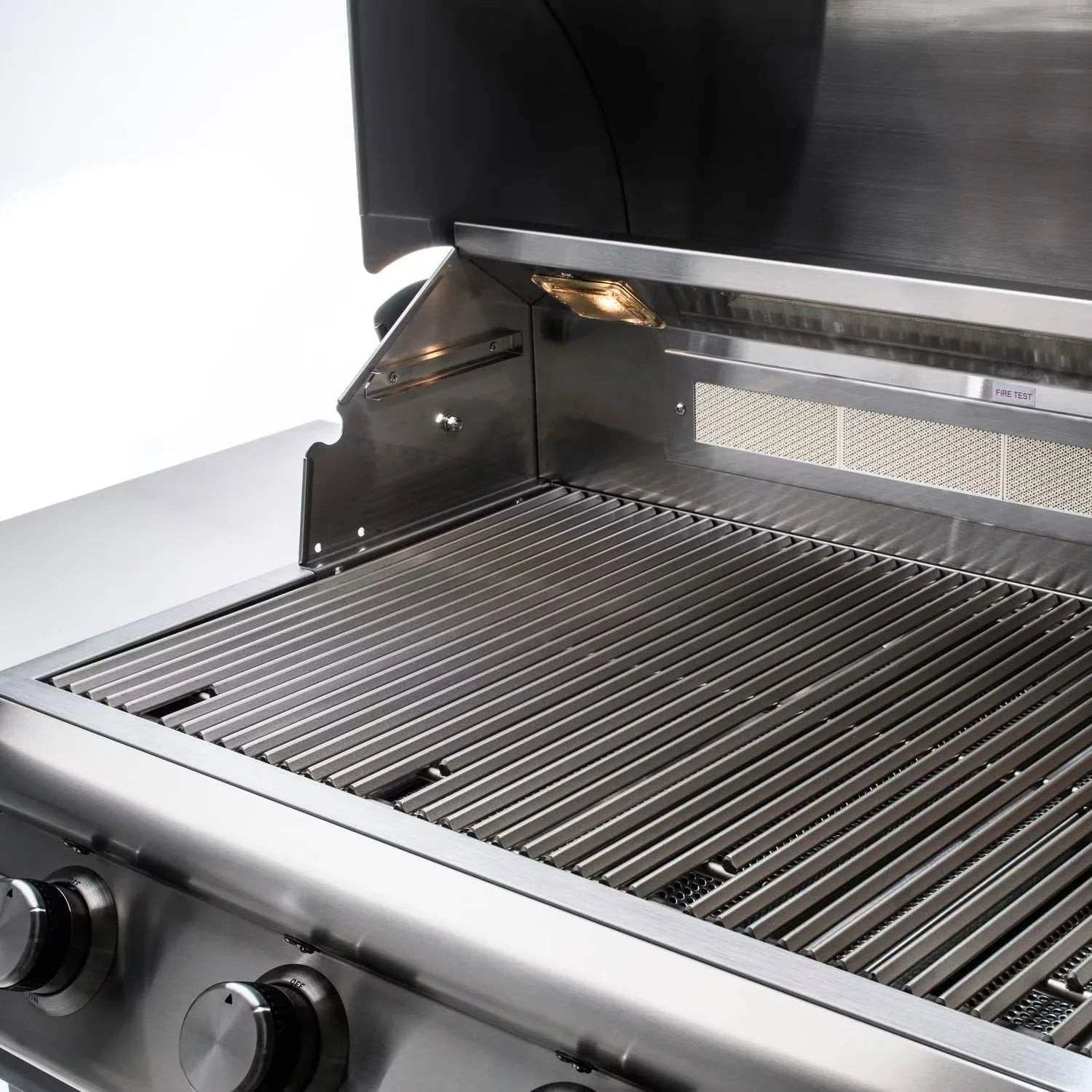 Open lid over stainless cooking grates with front burner area visible