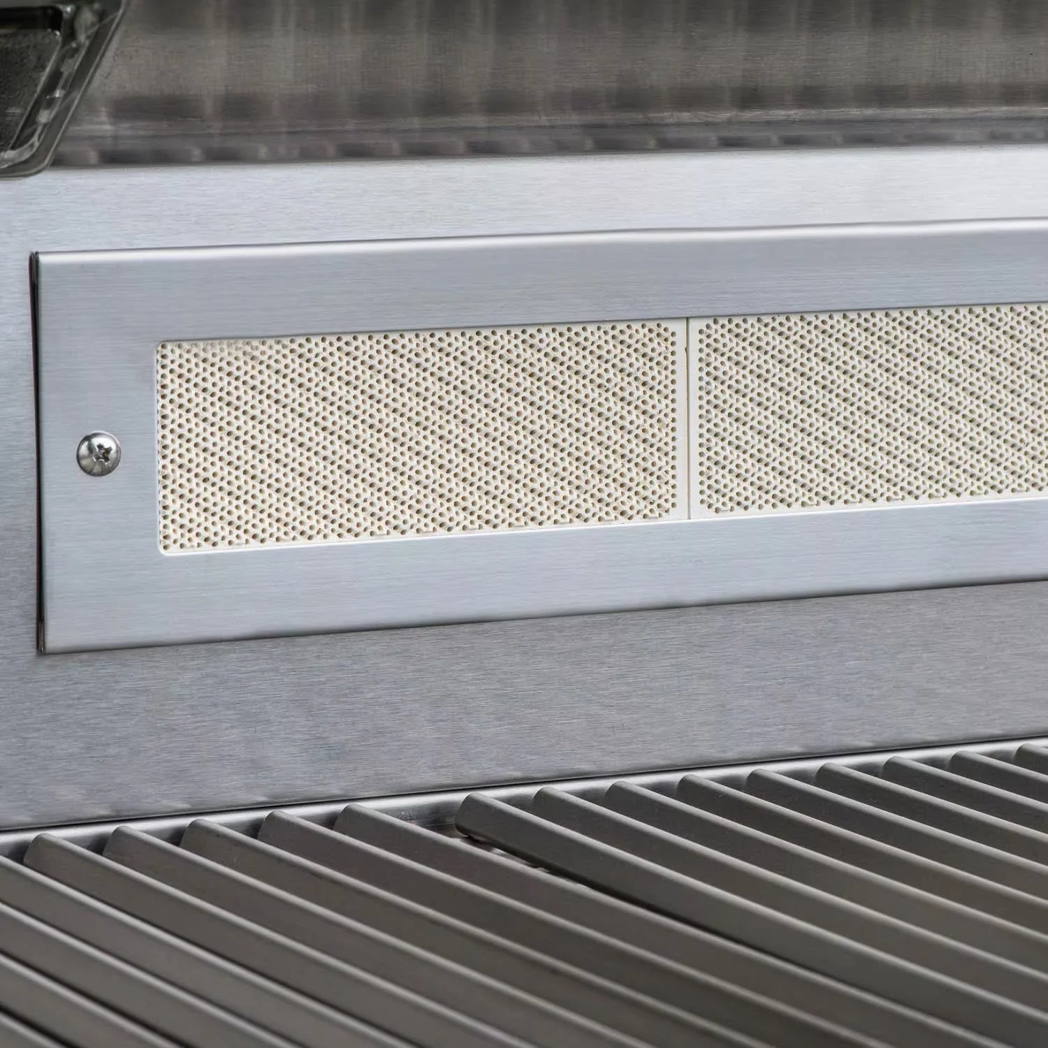 Perforated vent panel on stainless steel gas grill body above the cooking grates.