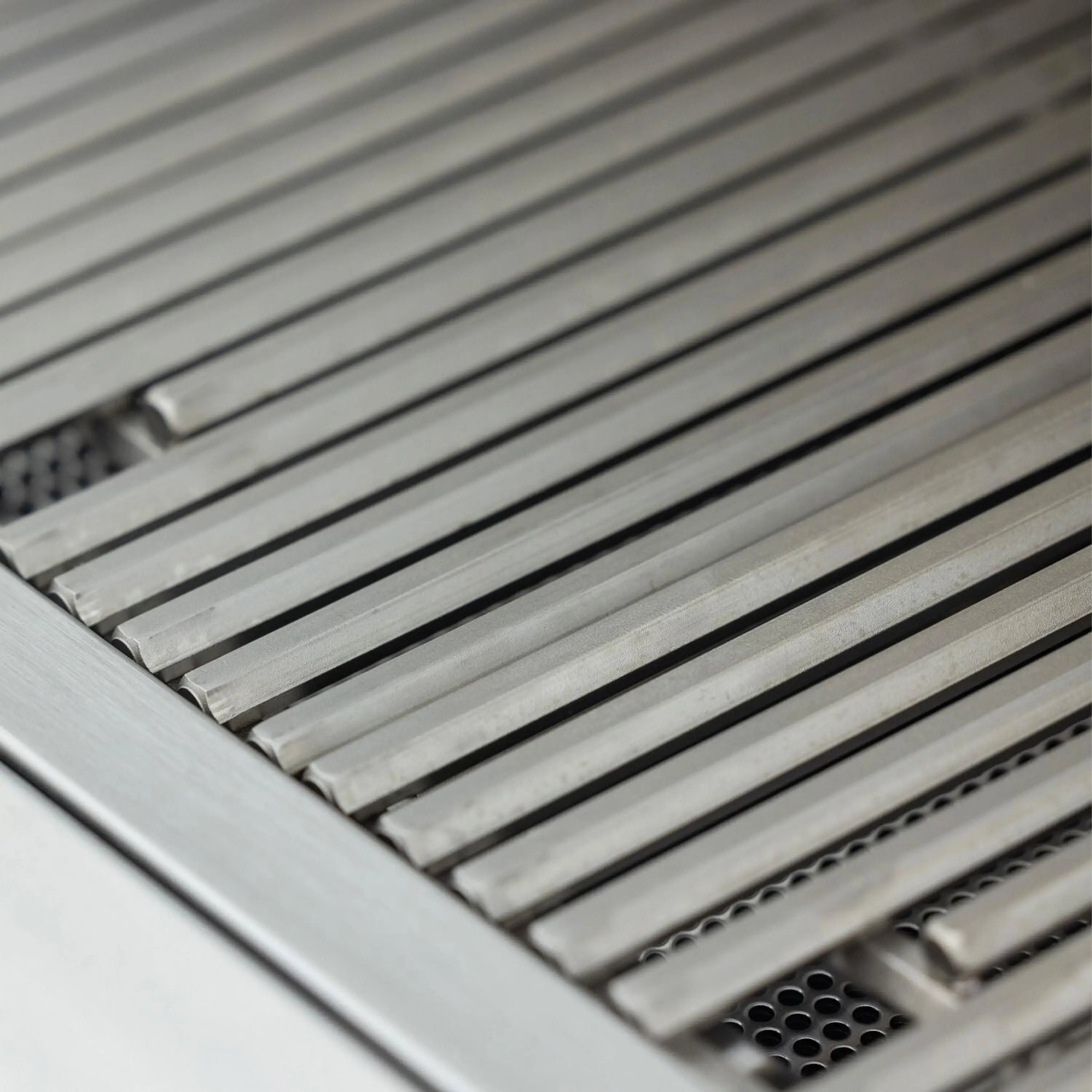 Close-up of stainless grill cooking grates with inner heat shield