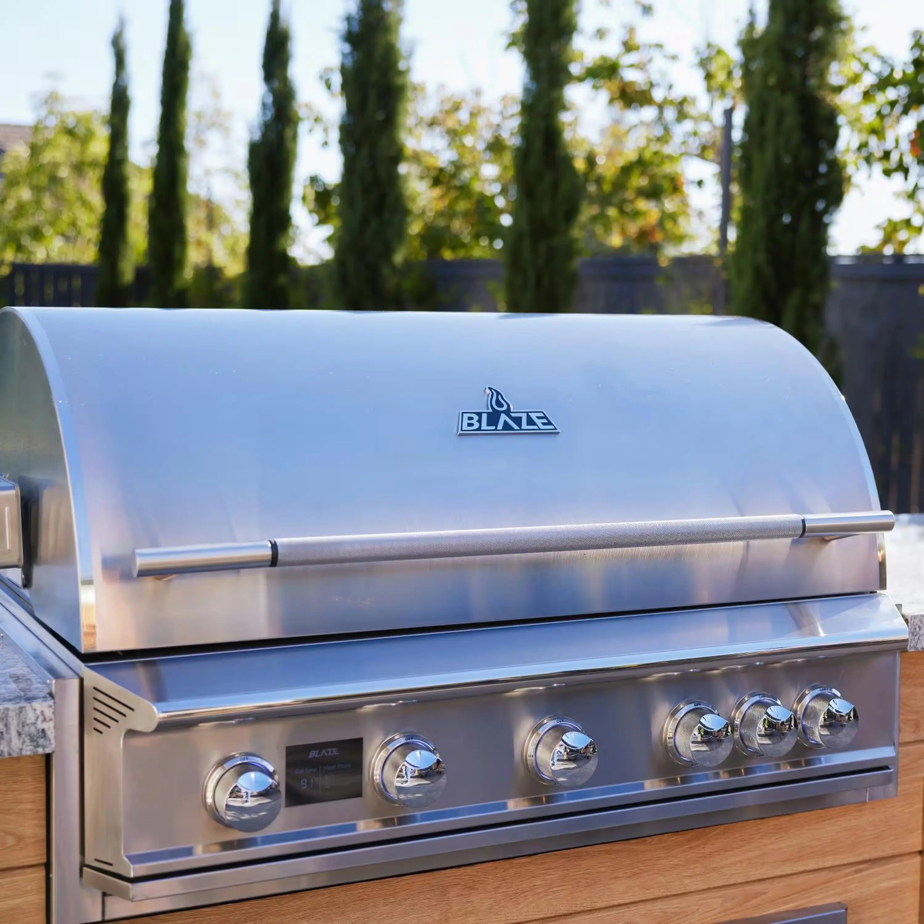 Stainless steel built-in gas grill with Blaze logo and wide hood, natural gas