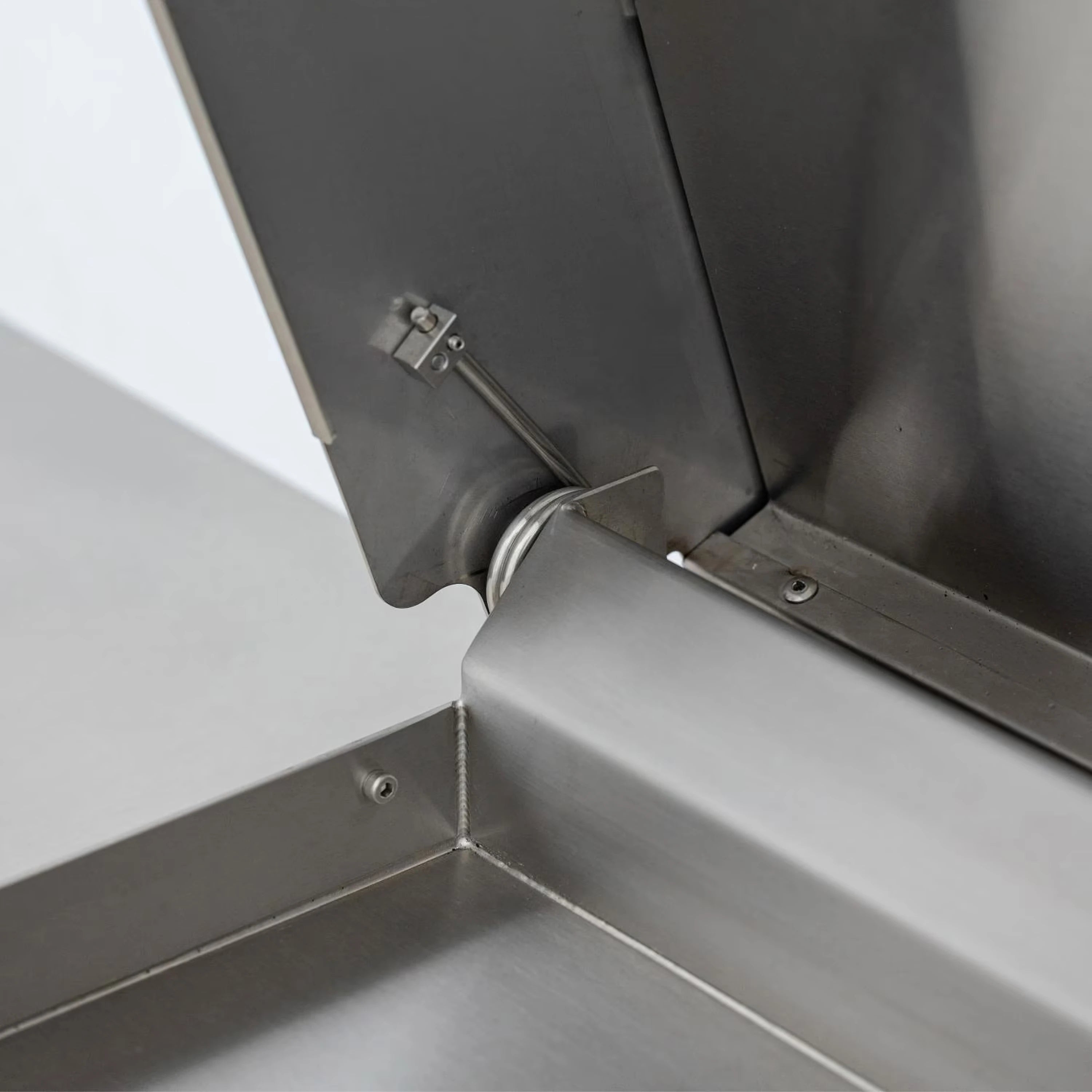 Gas griddle lid hinge and latch hardware on the stainless side panel