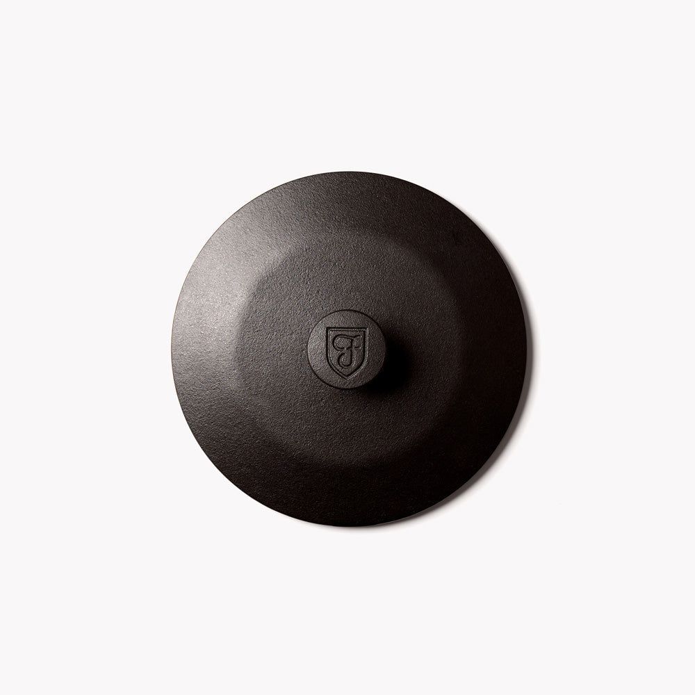 Cast iron skillet lid in dark finish with center knob
