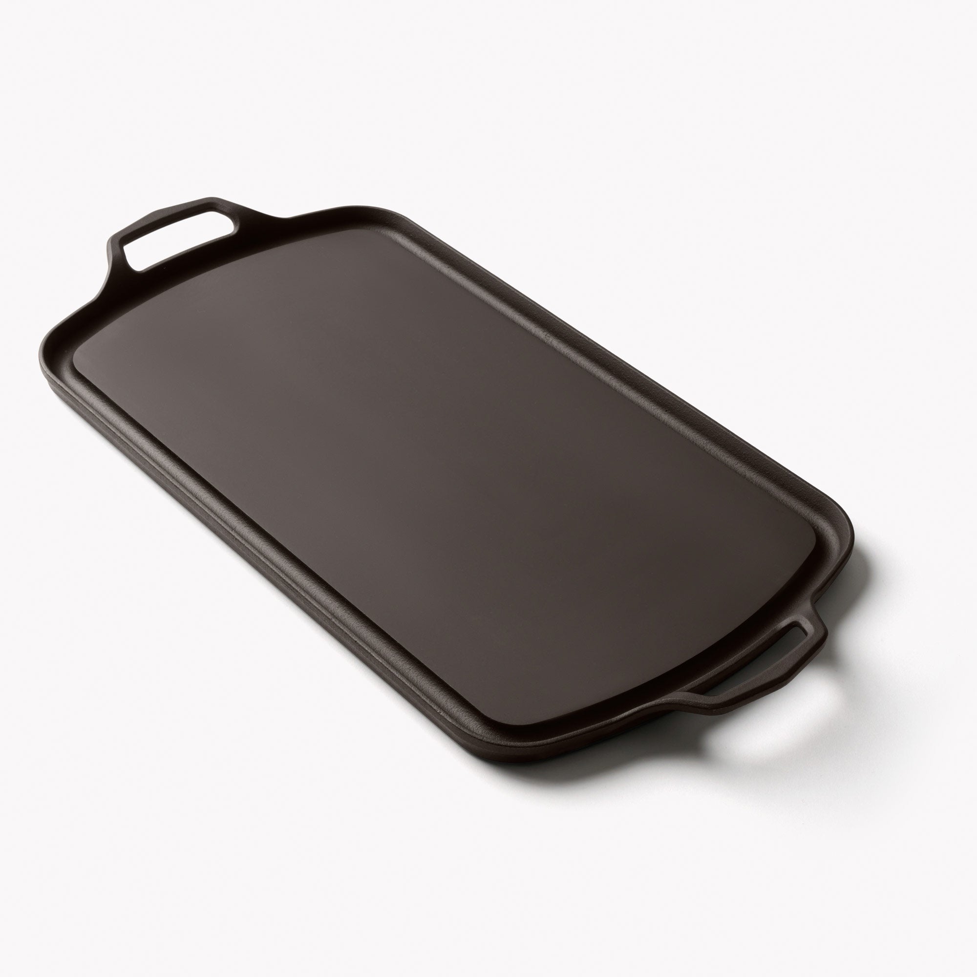 Long cast iron griddle with two side handles, dark nonstick-style surface