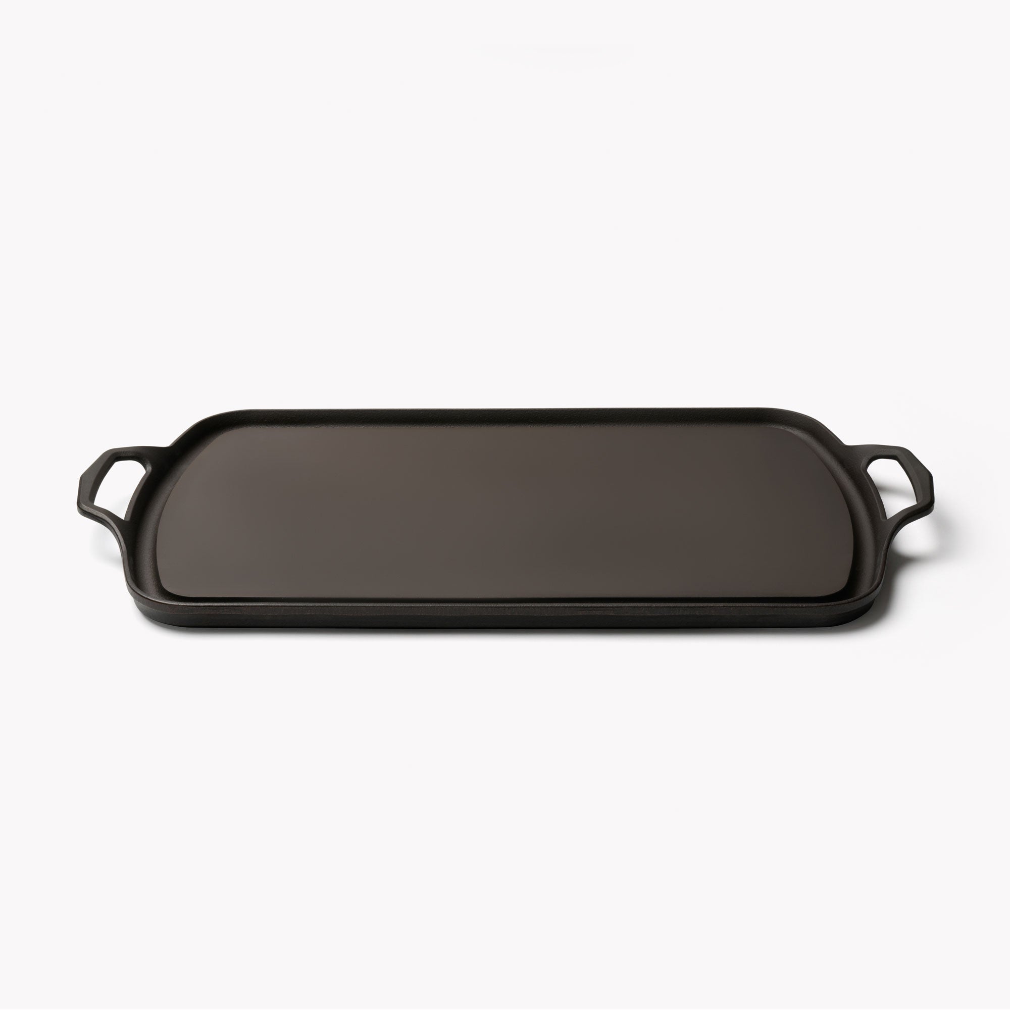 Rectangular cast iron griddle with two side handles, dark cooking surface