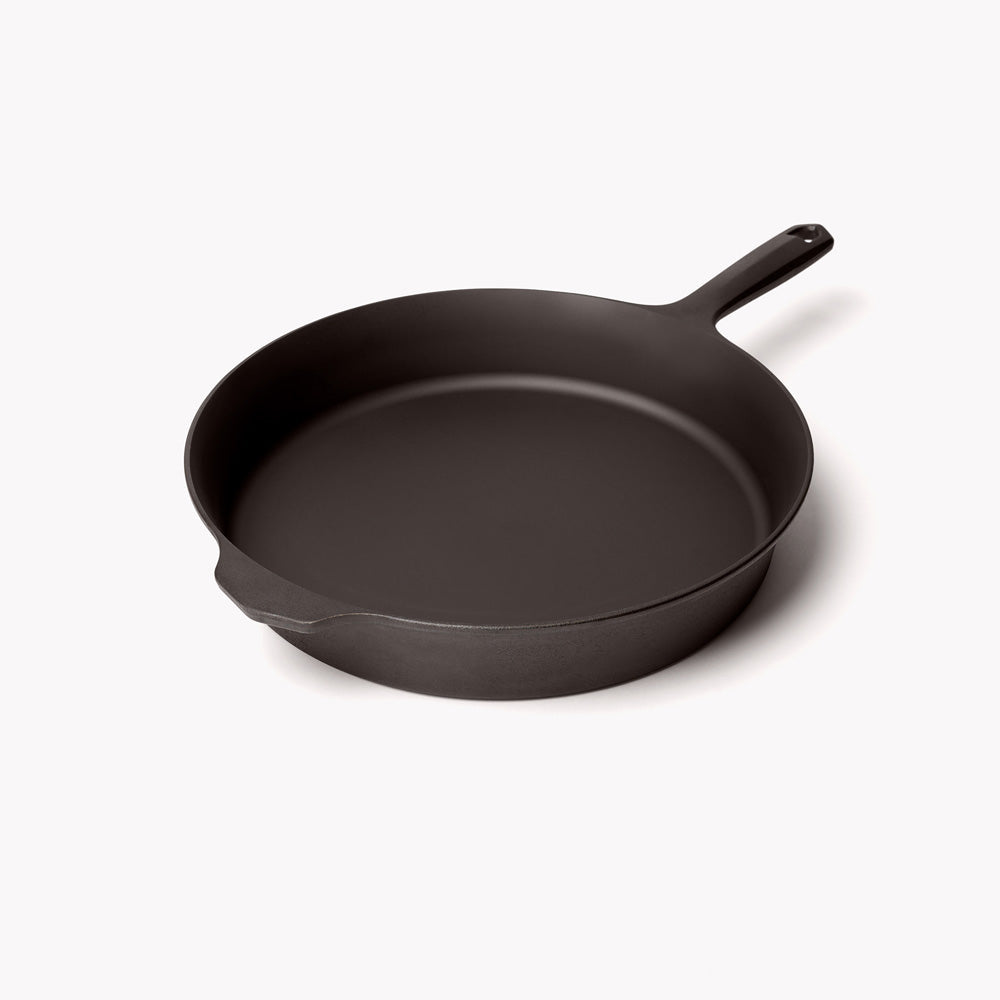 Cast iron skillet with short handle, deep round cooking surface, dark finish.