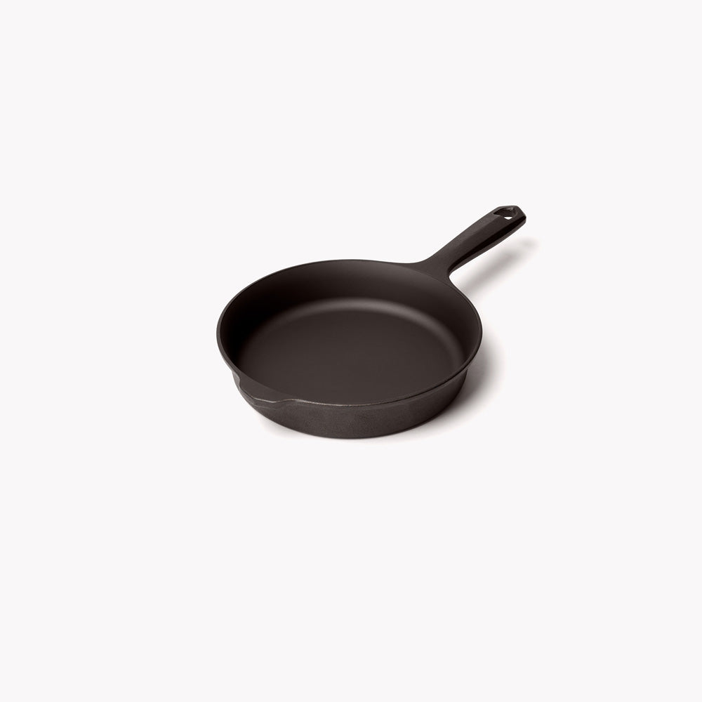 Cast iron skillet, black finish, shallow round pan with spout and short handle