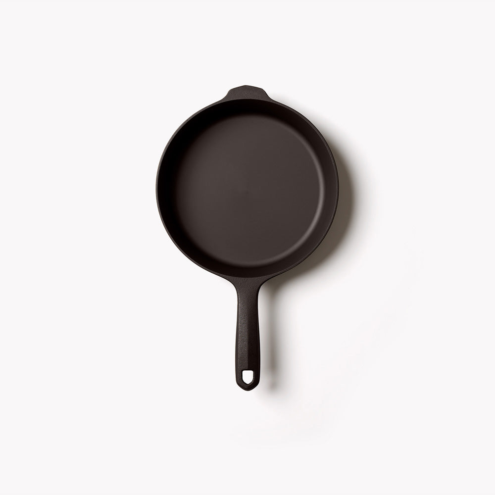 Black cast iron skillet with loop handle, round cooking surface